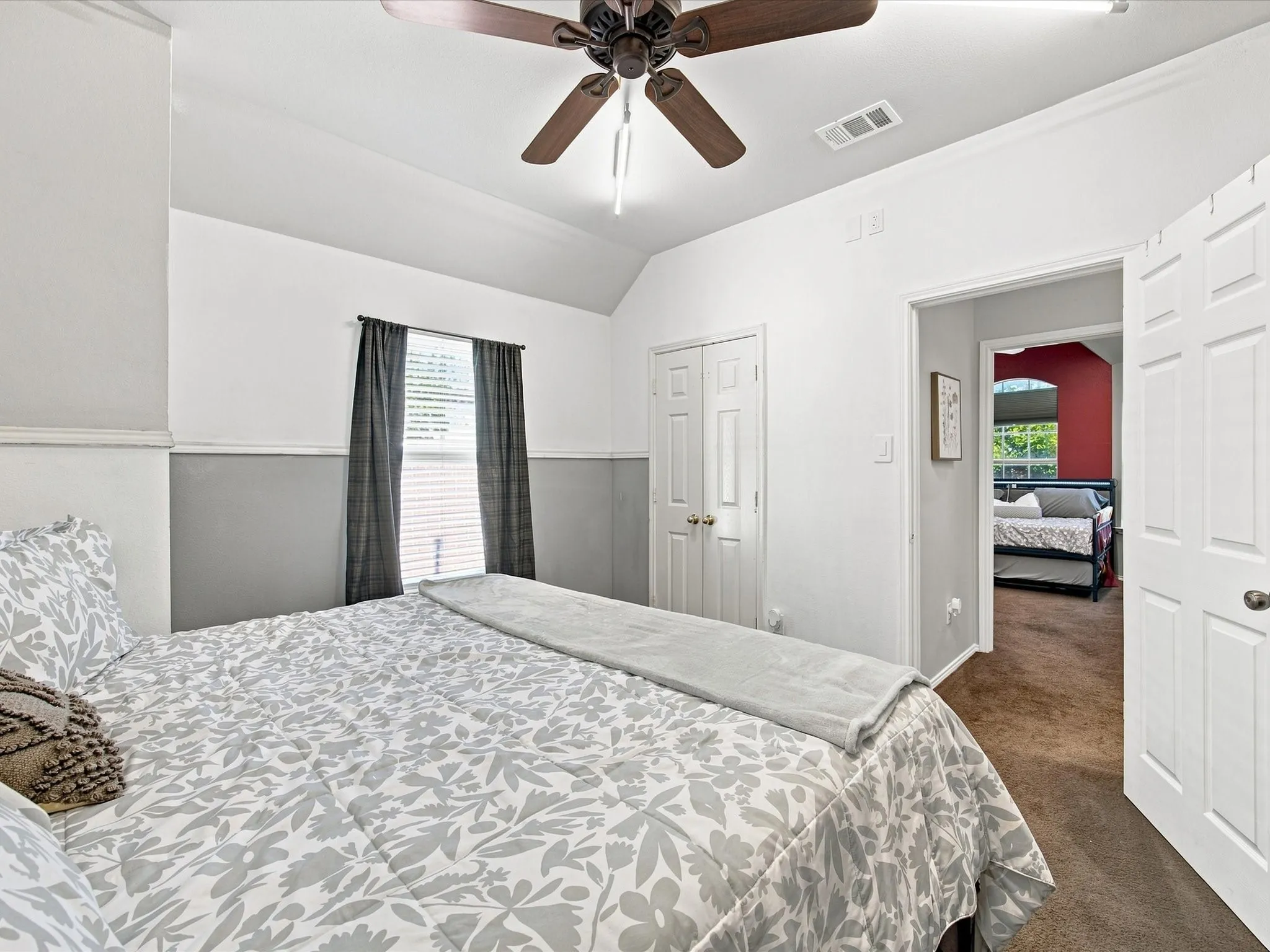 Vaulted ceiling with a ceiling fan, window with blinds, and white paneled doors