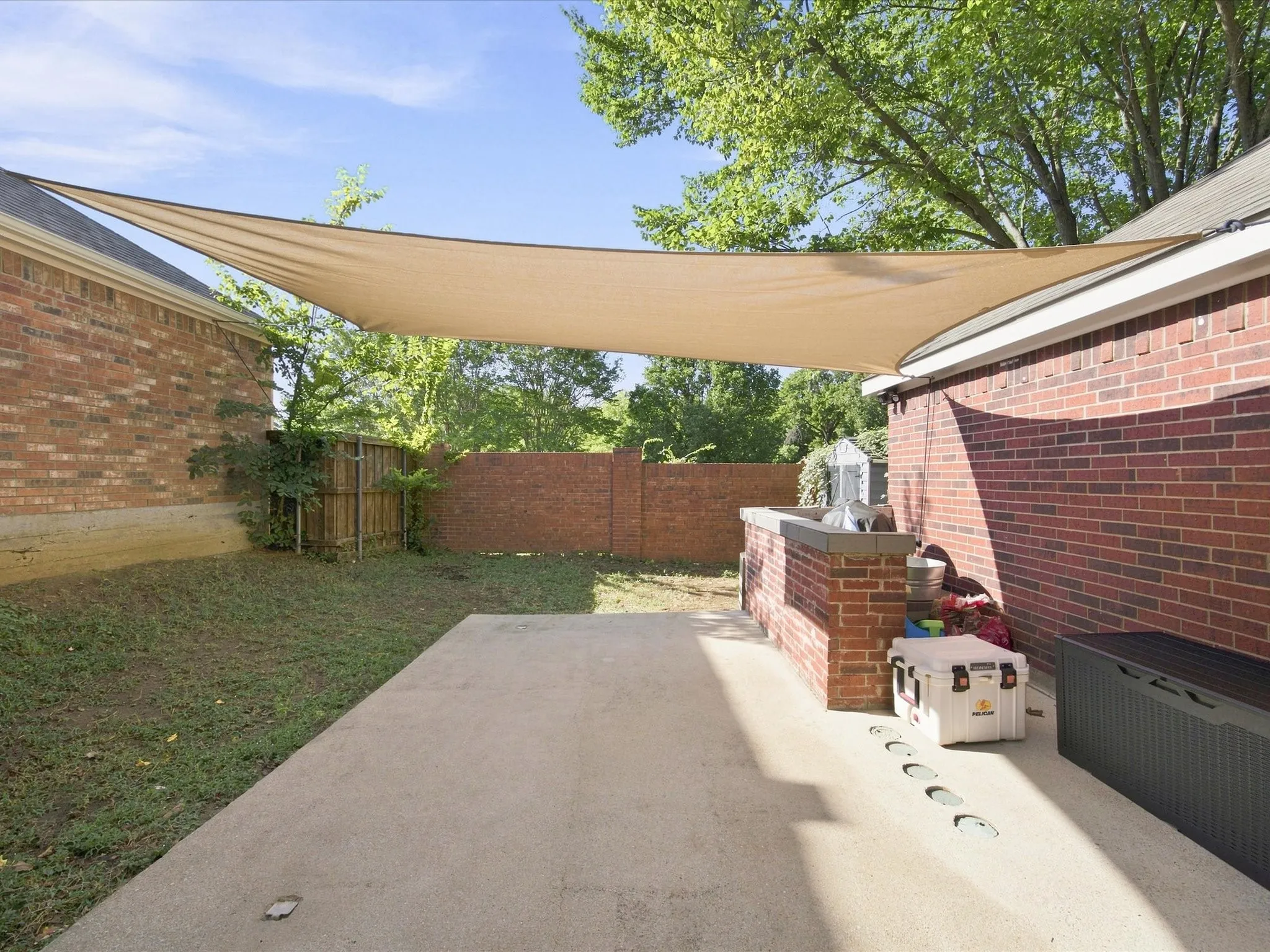 Expansive concrete patio with a built-in brick outdoor​​‌​​​​‌​​‌‌​‌‌​​​‌‌​‌​‌​‌​​​‌​​ kitchen