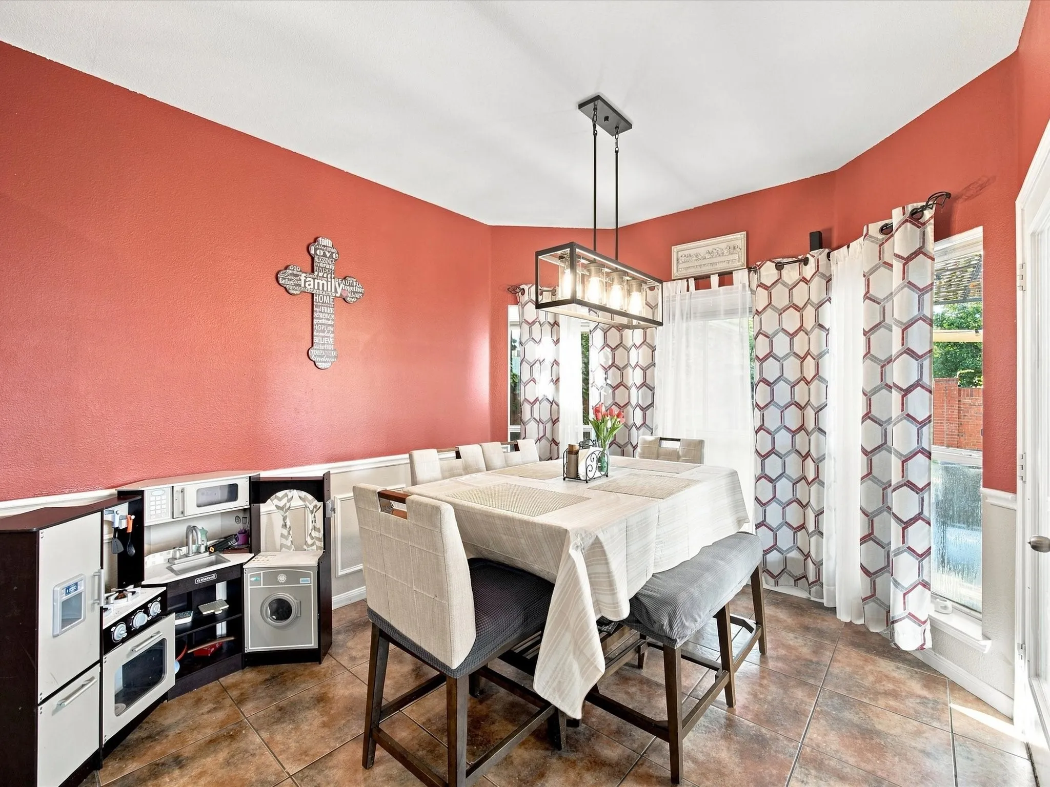 Tile flooring, chair rail molding, and a contemporary linear chandelier