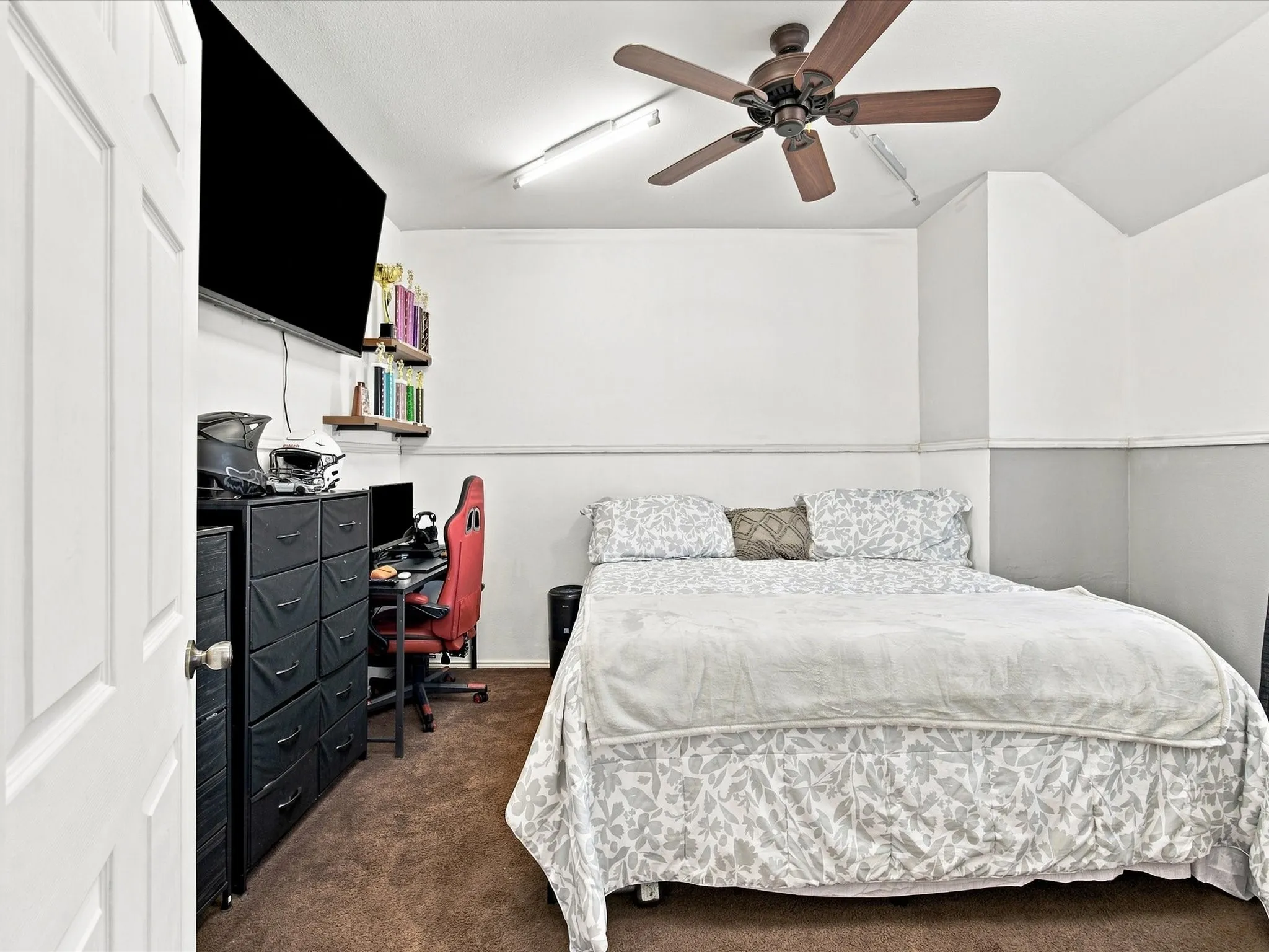 Ceiling fan, wall-mounted display, recessed lighting, wall shelving, and brown carpeting