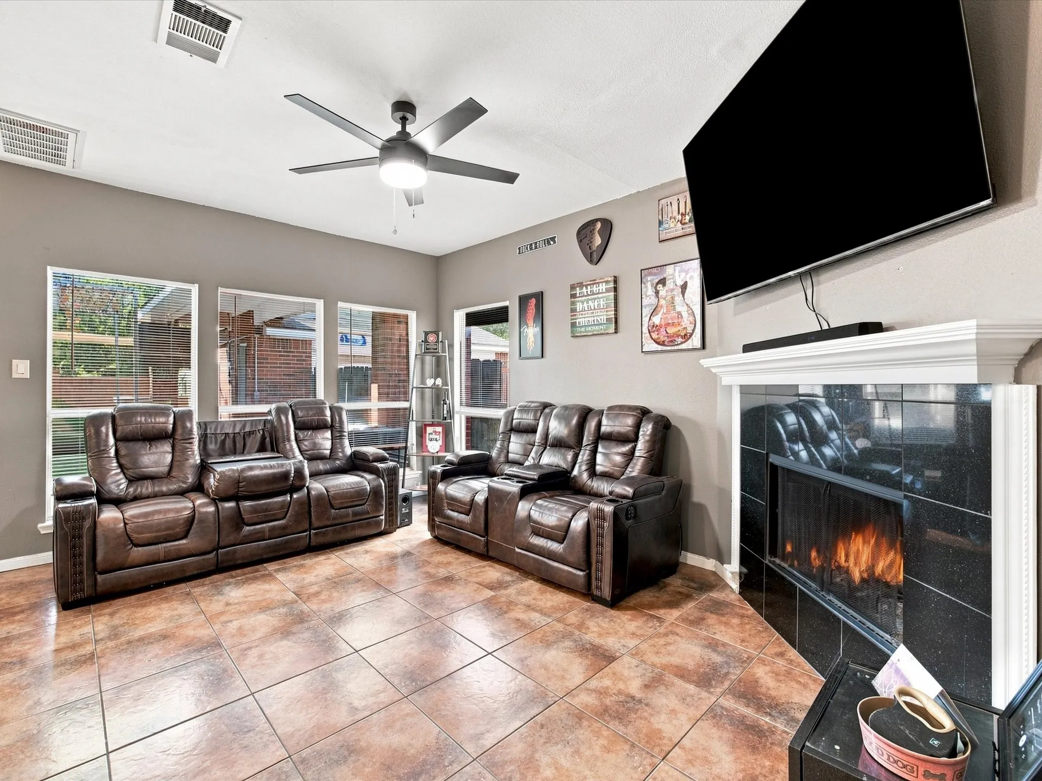 Ceramic tile flooring, white mantel, and a ceiling fan with integrated lighting