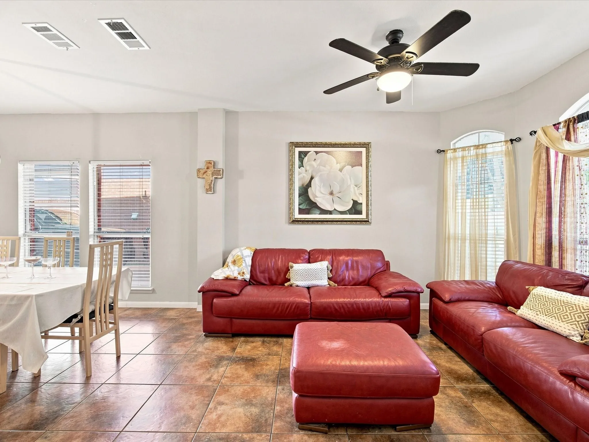 Recessed lighting, ceiling fan, arched window, tile flooring, and multiple windows