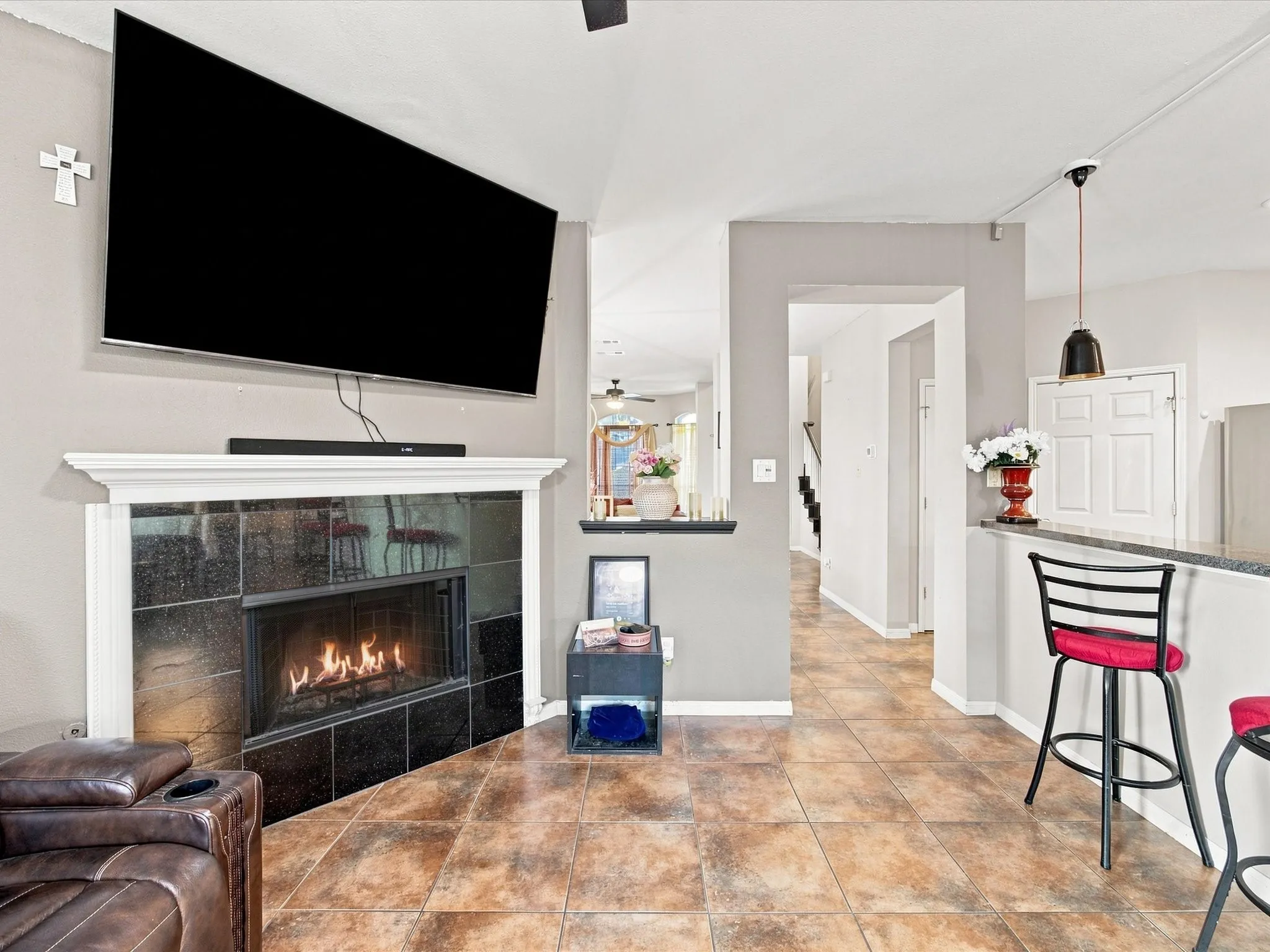 Angled fireplace with dark tile surround and white mantel
