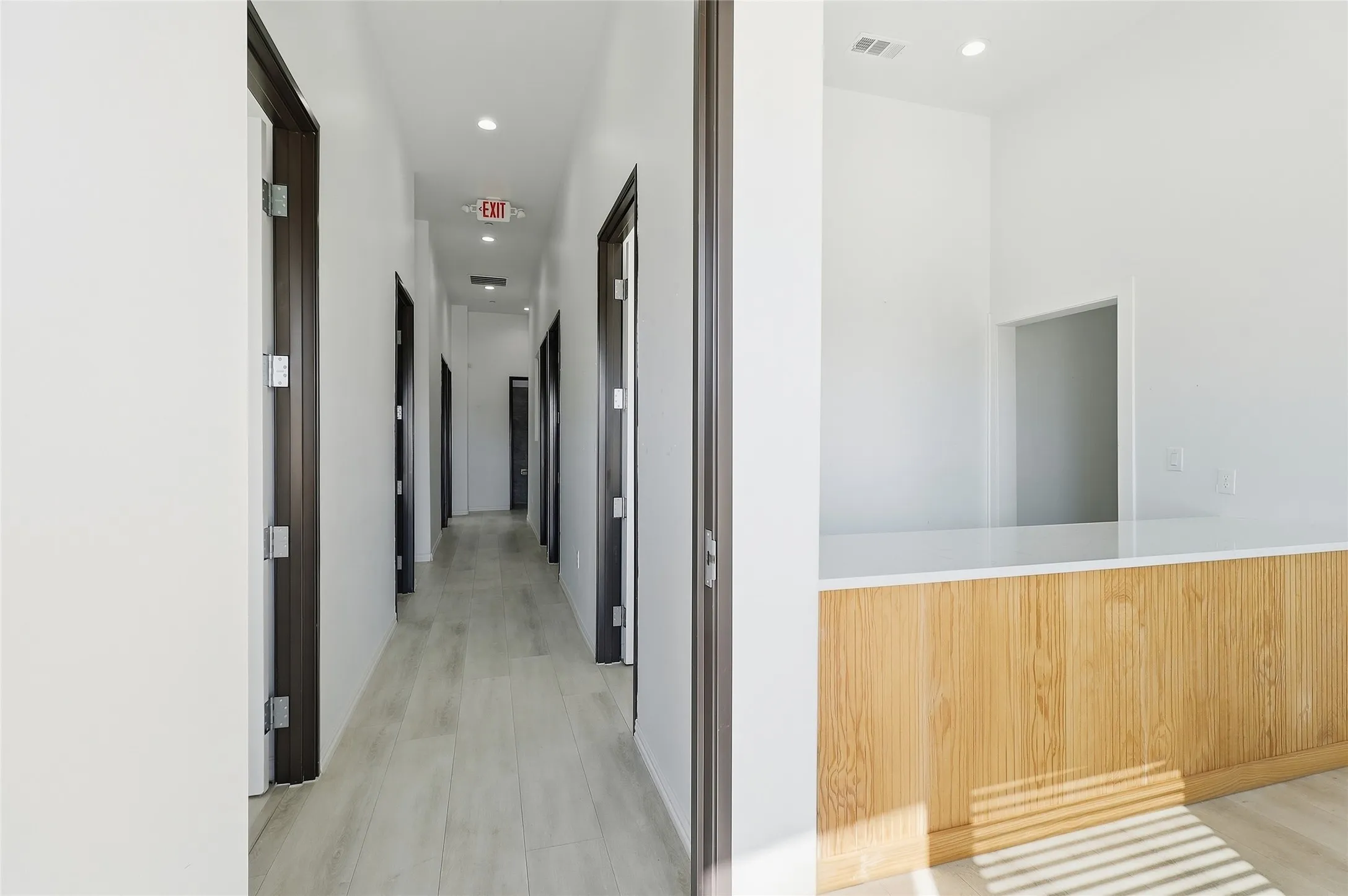 Hallway featuring light wood-finish flooring and recessed lighting