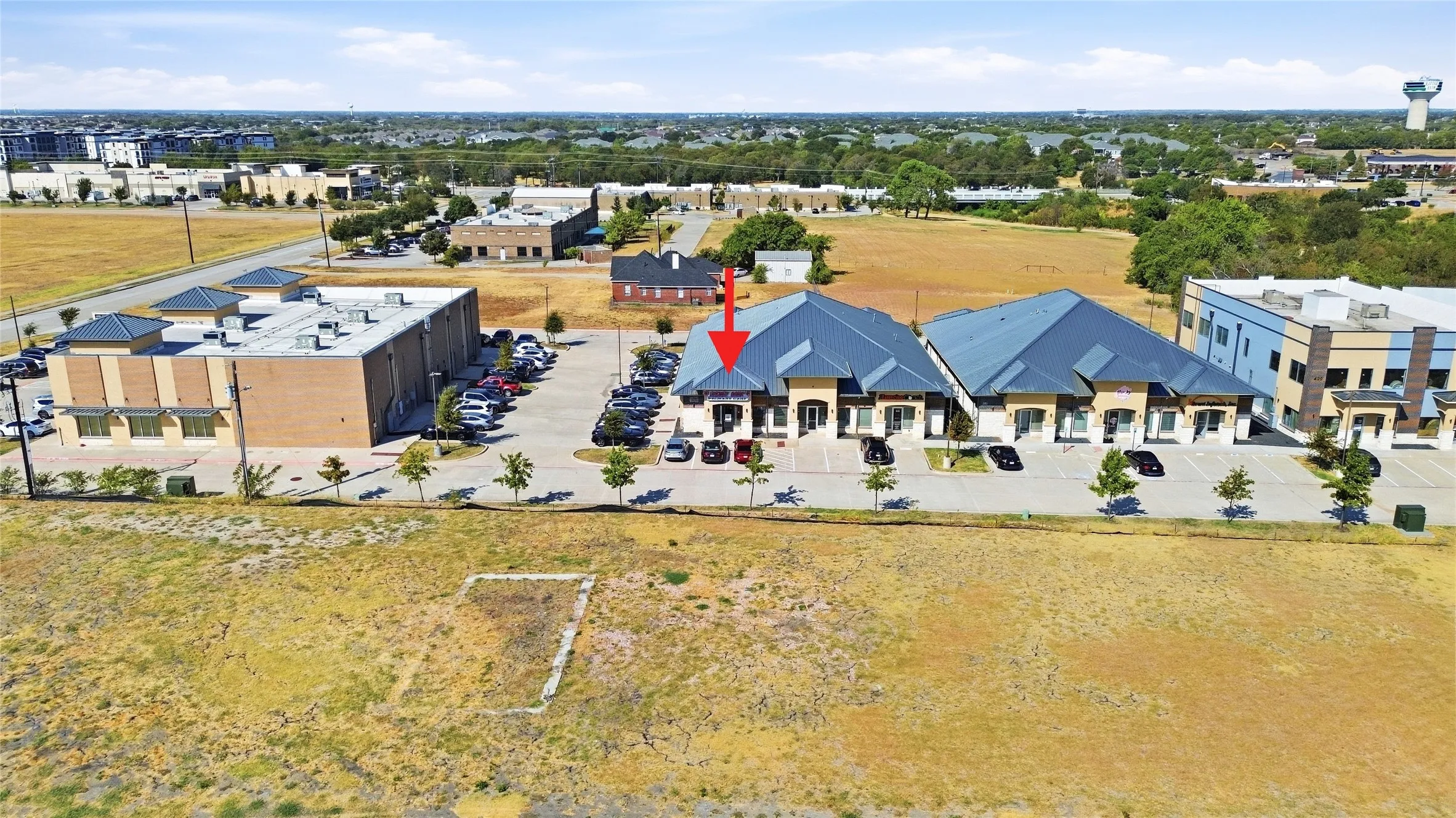 Property features a multi-unit commercial building with a dark-colored roof and light-toned exterior walls