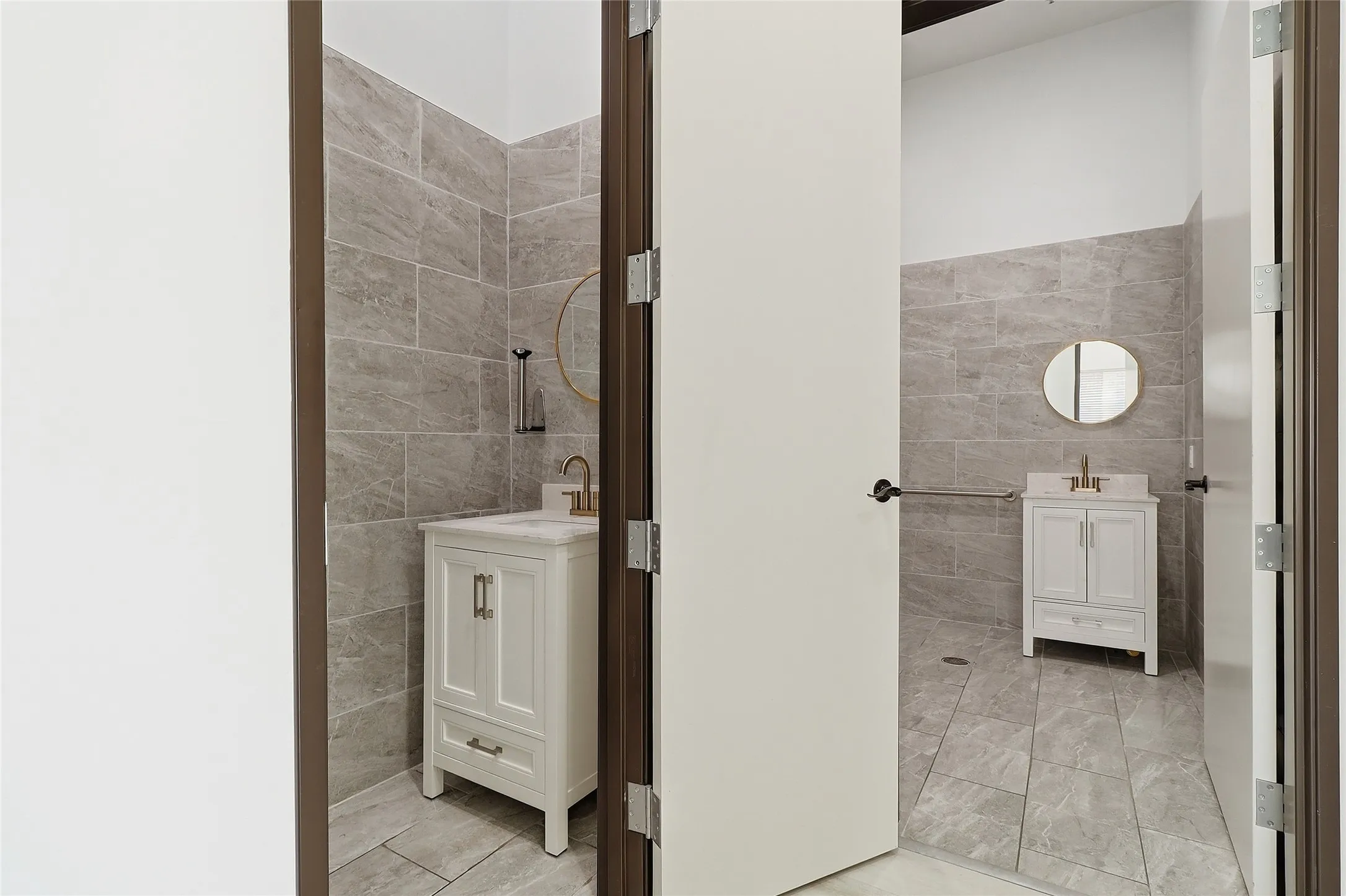 White vanity with a rectangular sink, gold-finish faucet, and round mirror