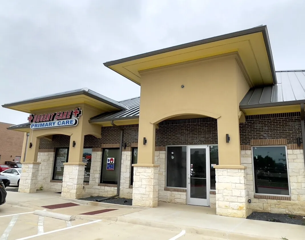 Commercial storefront with a metal roof, stone and brick facade, and an arched entryway