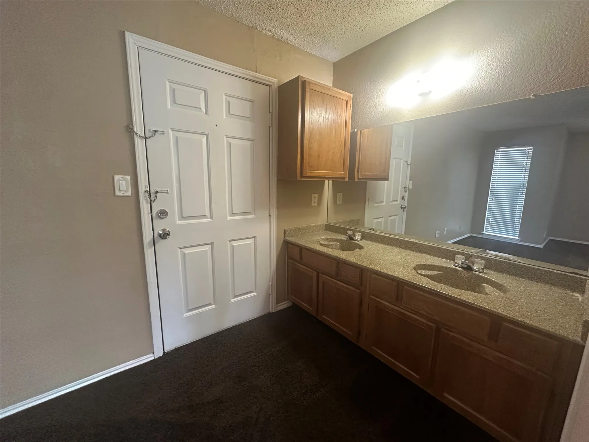 Double vanity with built-in cabinetry, dual sinks, and a full-width mirror