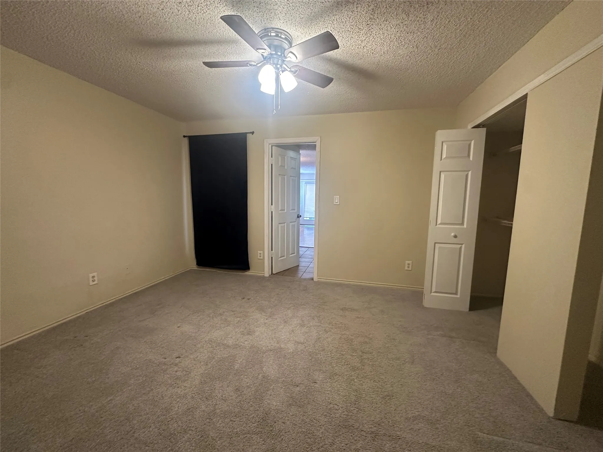 Room featuring carpet flooring, ceiling fan with integrated lighting, and a closet with bifold doors
