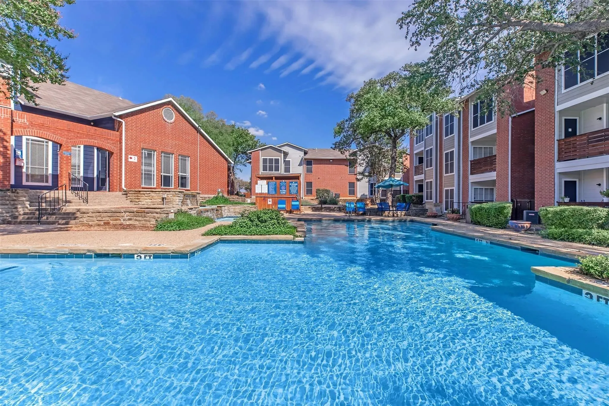 Extensive swimming pool with integrated tanning ledge, surrounded by a paved patio