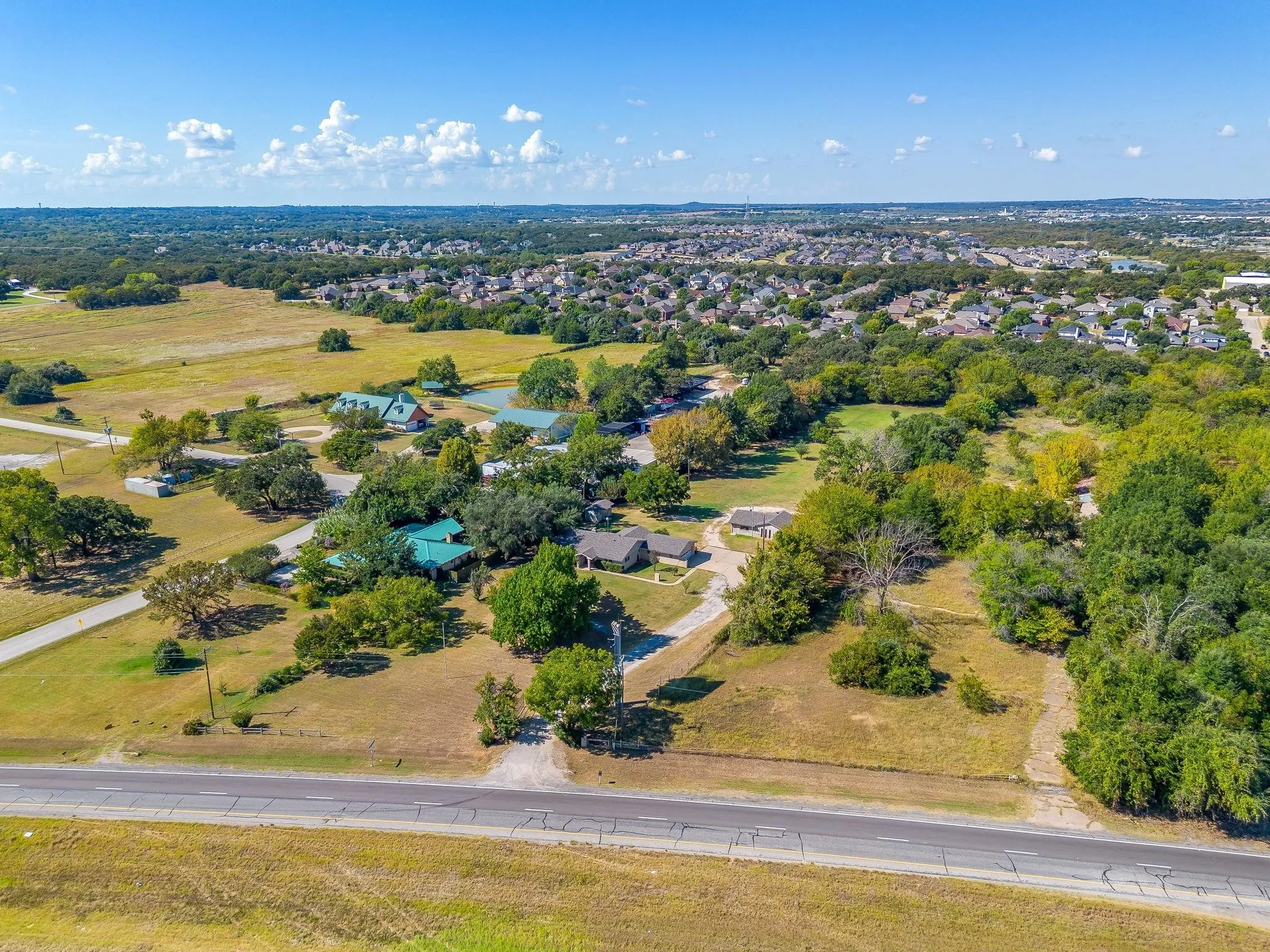 Expansive property with multiple structures, mature trees, and direct road access