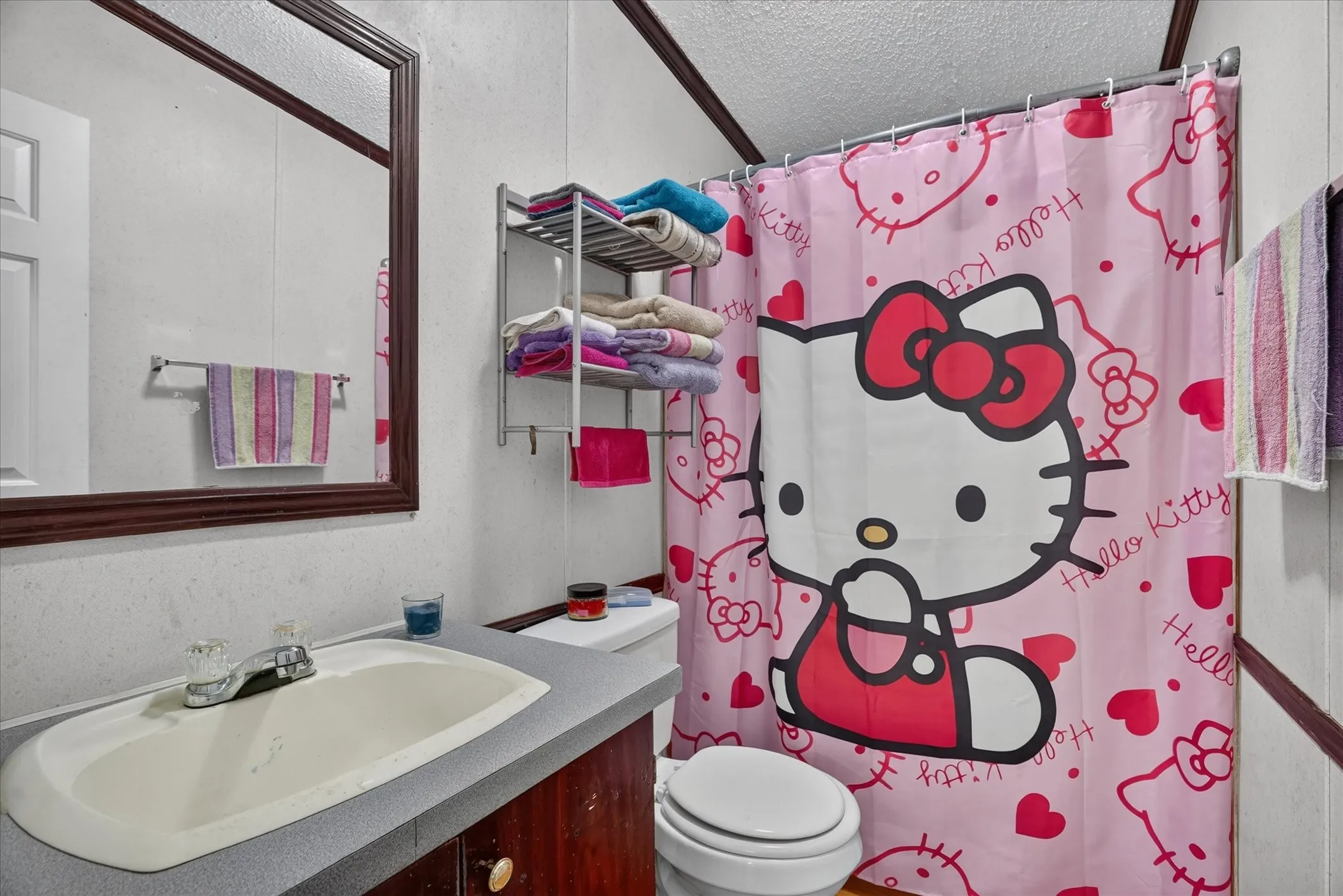 Bathroom vanity with integrated sink, mounted mirror, and wall-mounted shelving unit