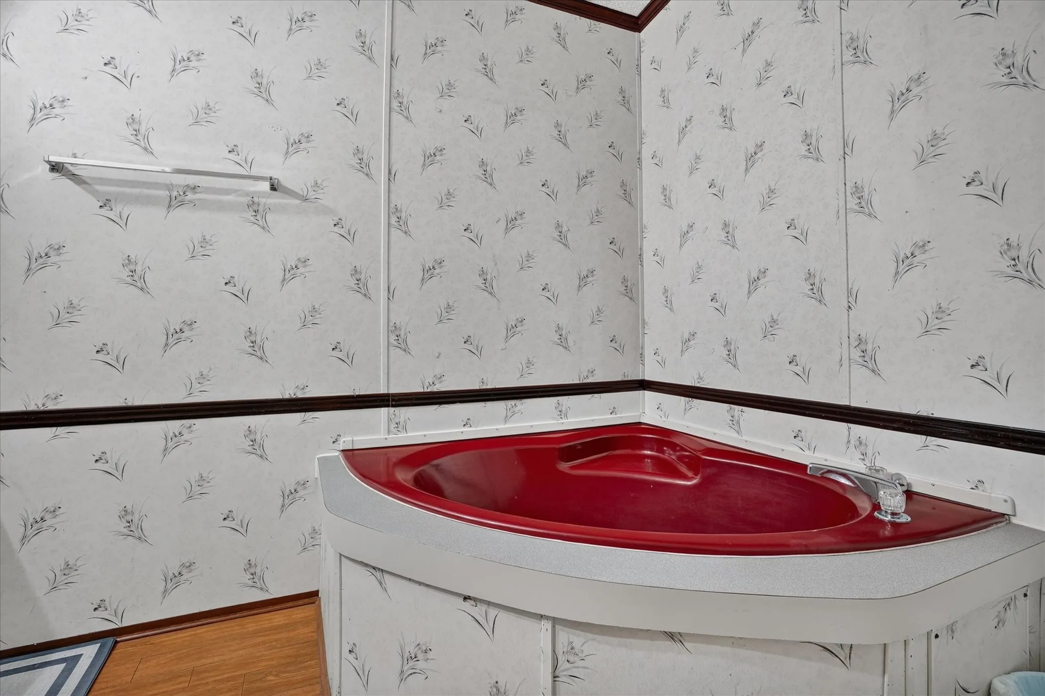 Corner soaking tub with a red basin and white surround