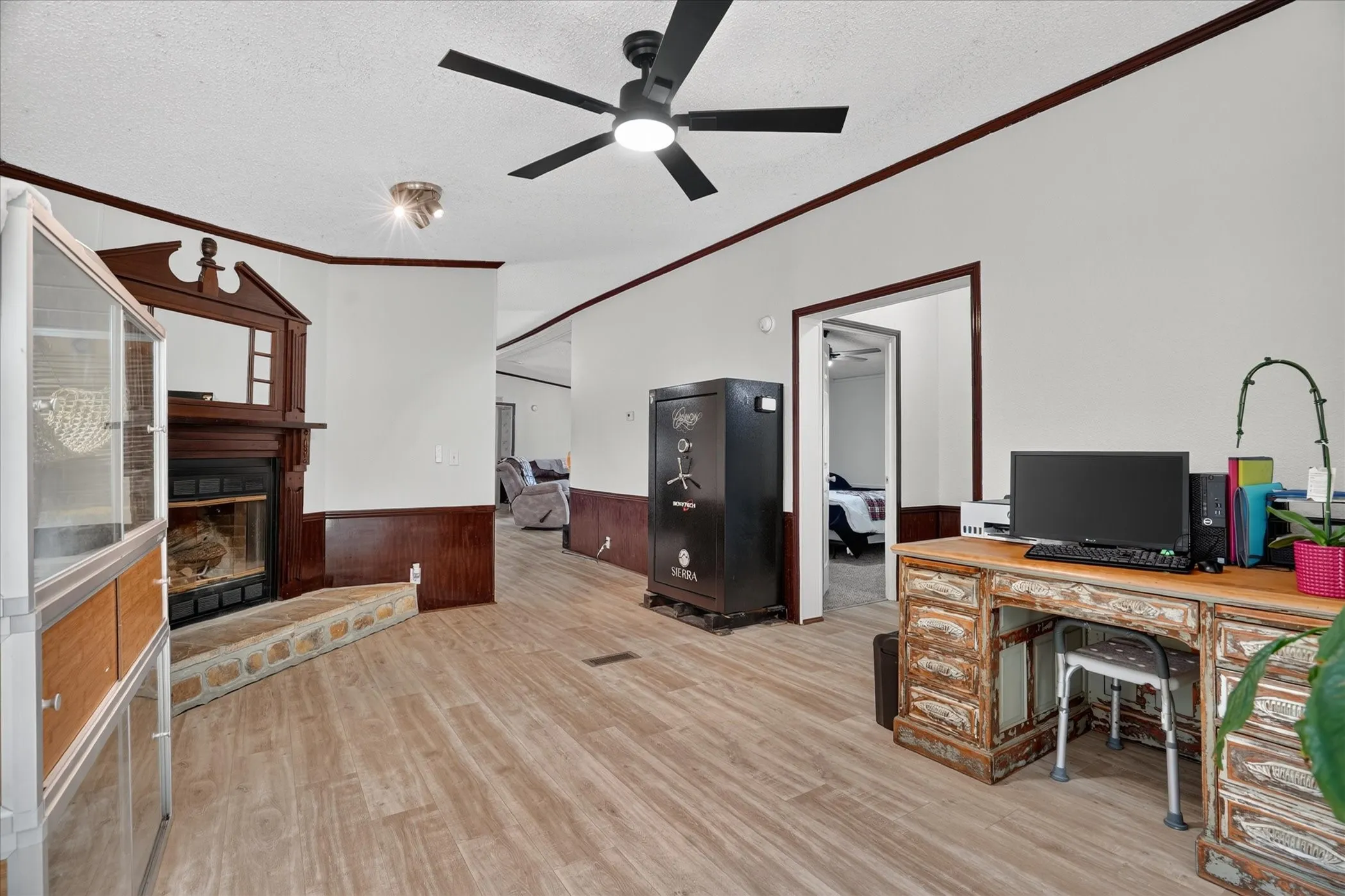 Wood-finish flooring throughout, featuring a fireplace with a stone hearth and wood surround
