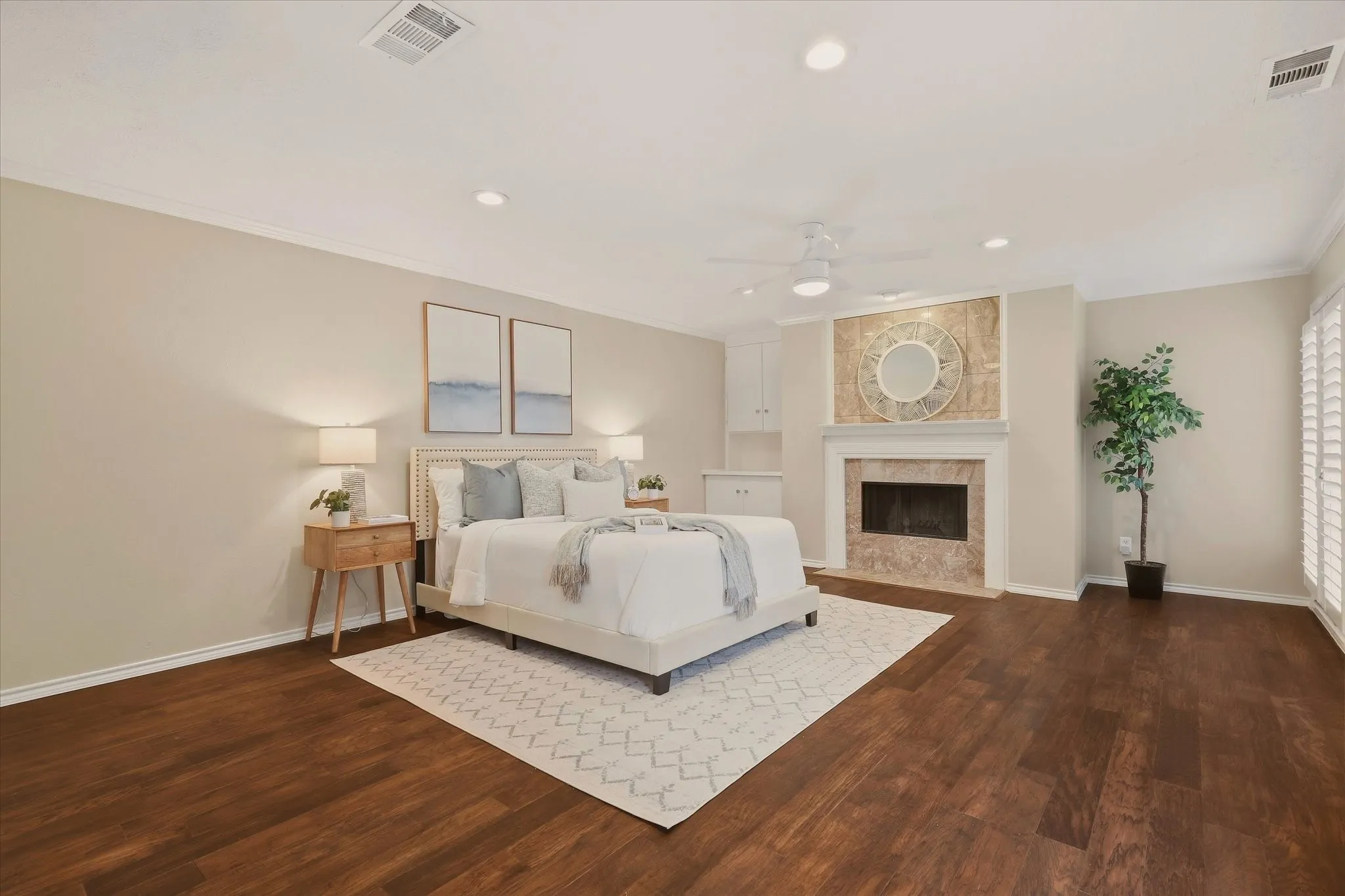 Primary bedroom with a fireplace and hardwood floors.