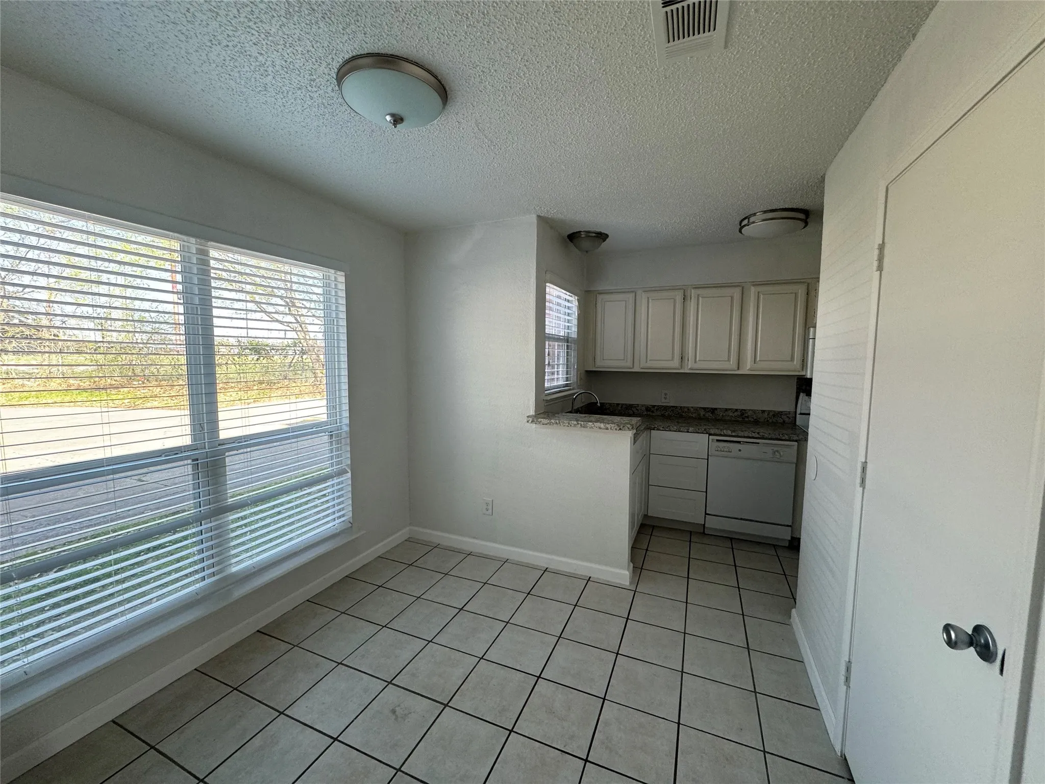 Kitchen featuring visible vents, light tile patterned flooring, dishwasher, a sink, and​​‌​​​​‌​​‌‌​‌‌​​​‌‌​‌​‌​‌​​​‌​​ baseboards