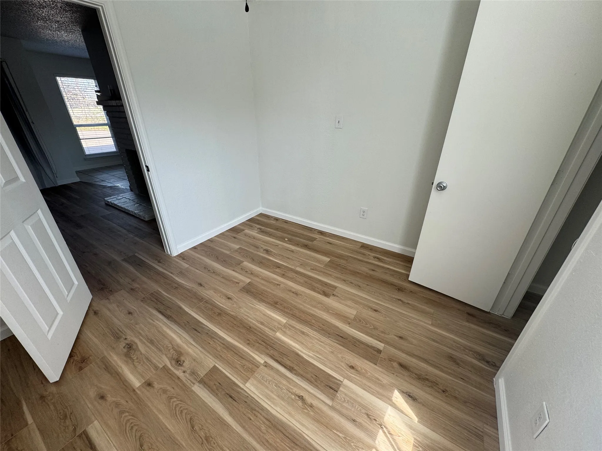 Unfurnished bedroom with baseboards, light wood finished floors, and a textured ceiling