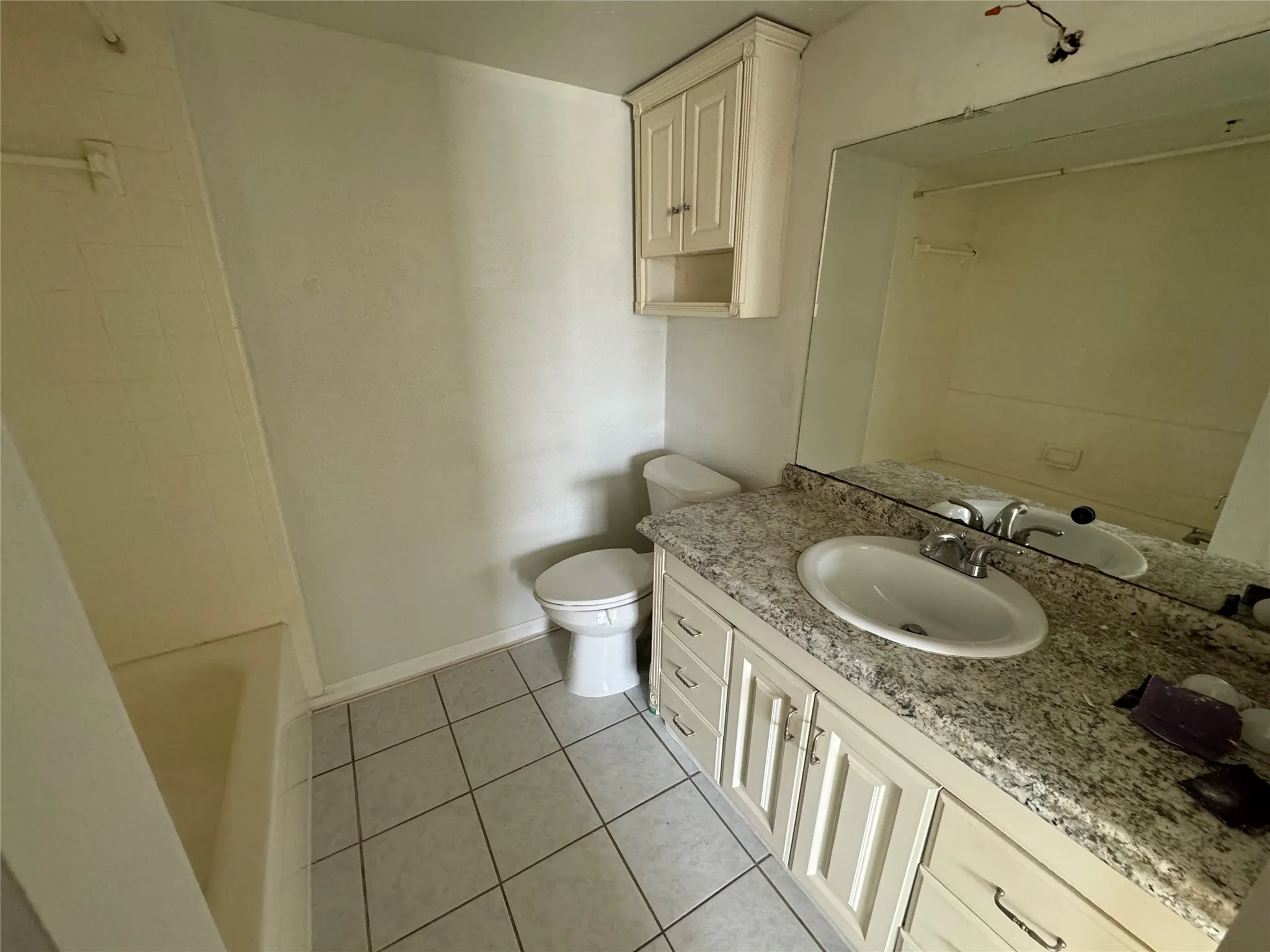 Full bathroom with baseboards, toilet, tub / shower combination, vanity, and tile patterned floors