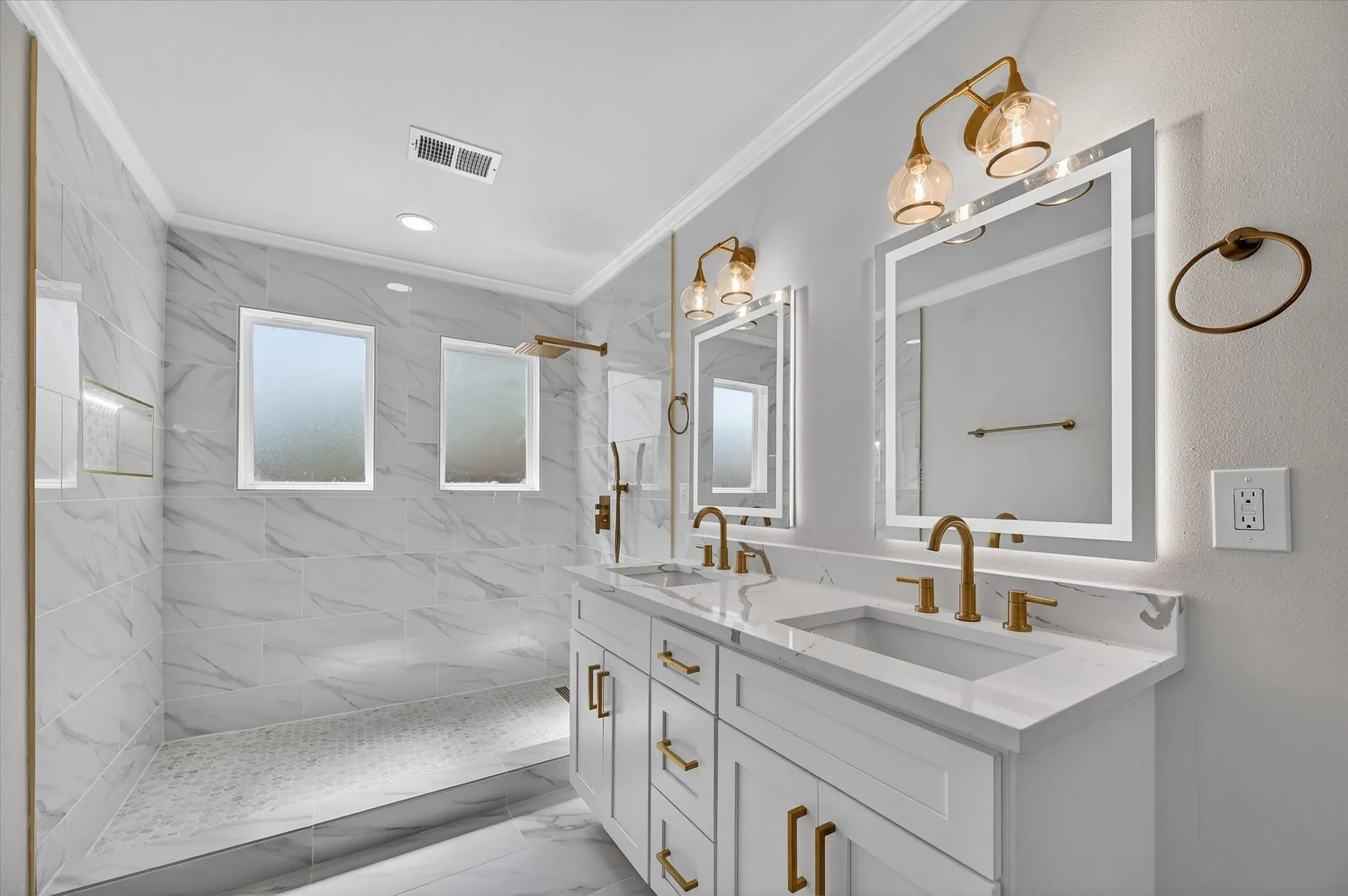 Dual vanity with white cabinetry, gold-finish hardware, and quartz countertops