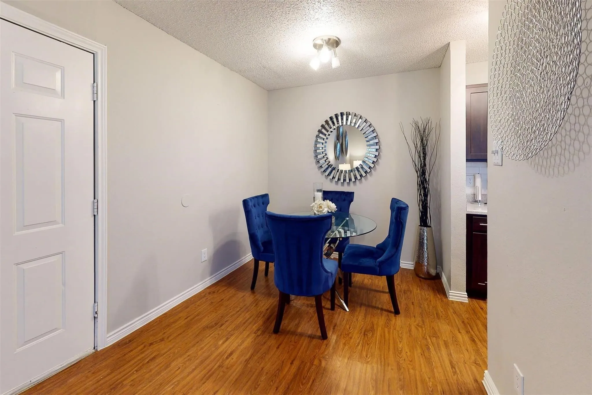 Wood-finish flooring with a neutral wall color, recessed lighting, and a white paneled door