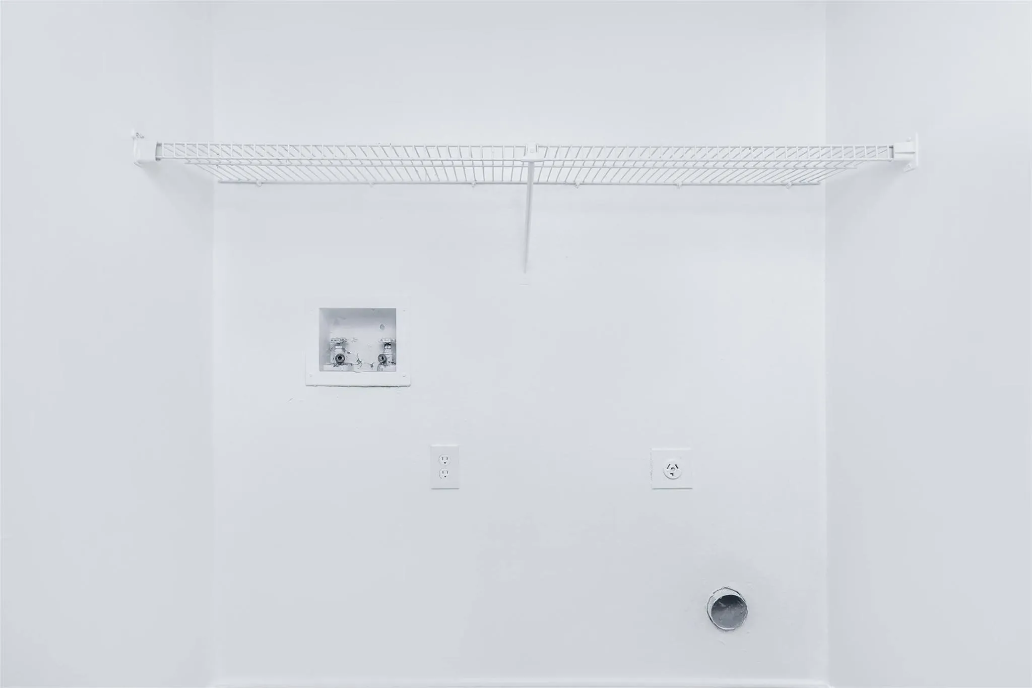 Wall-mounted wire shelving, utility hook-ups, and a dryer vent
