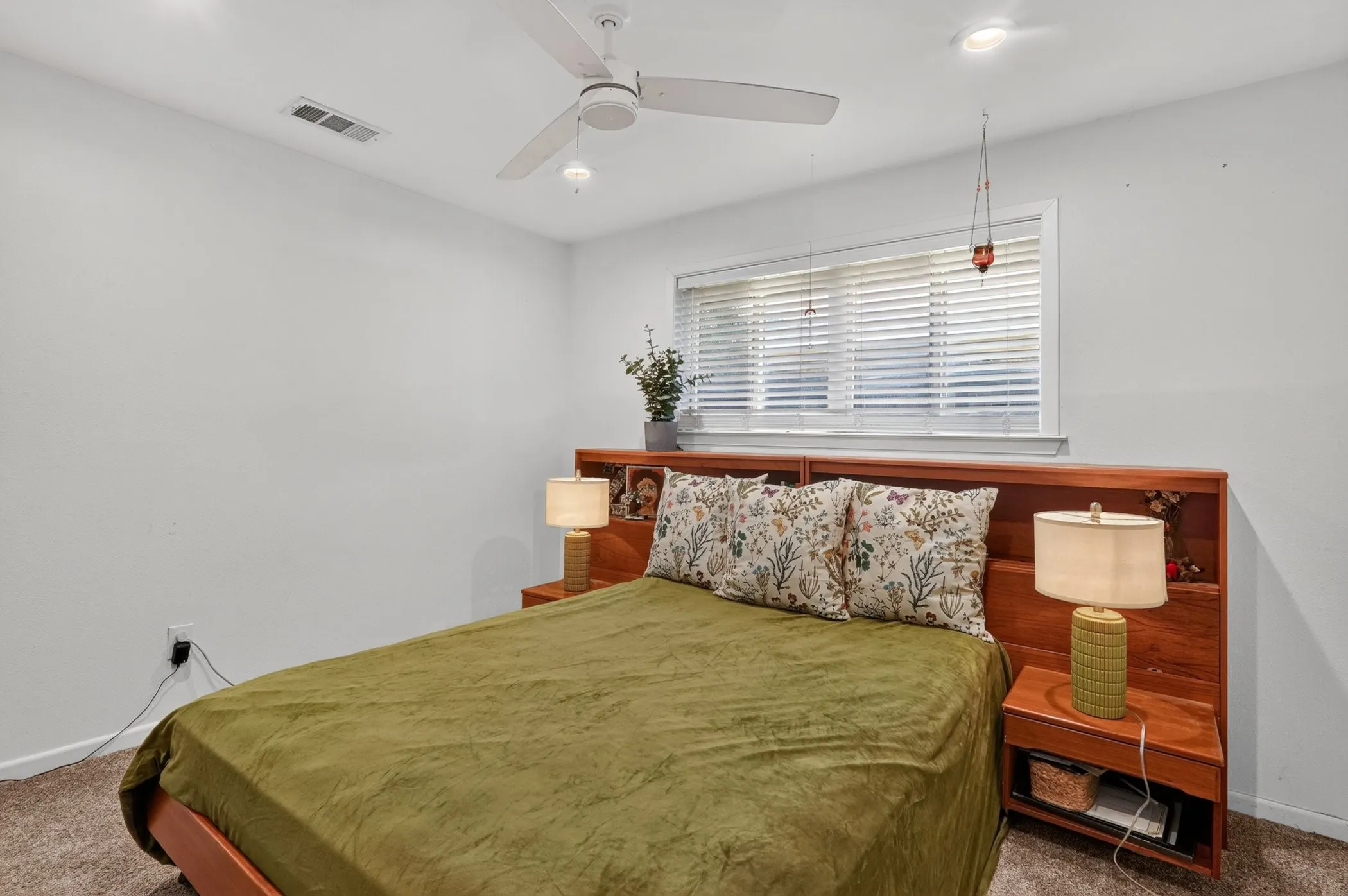 Recessed lighting, ceiling fan, window with blinds, wood-finish built-in headboard, and carpet flooring