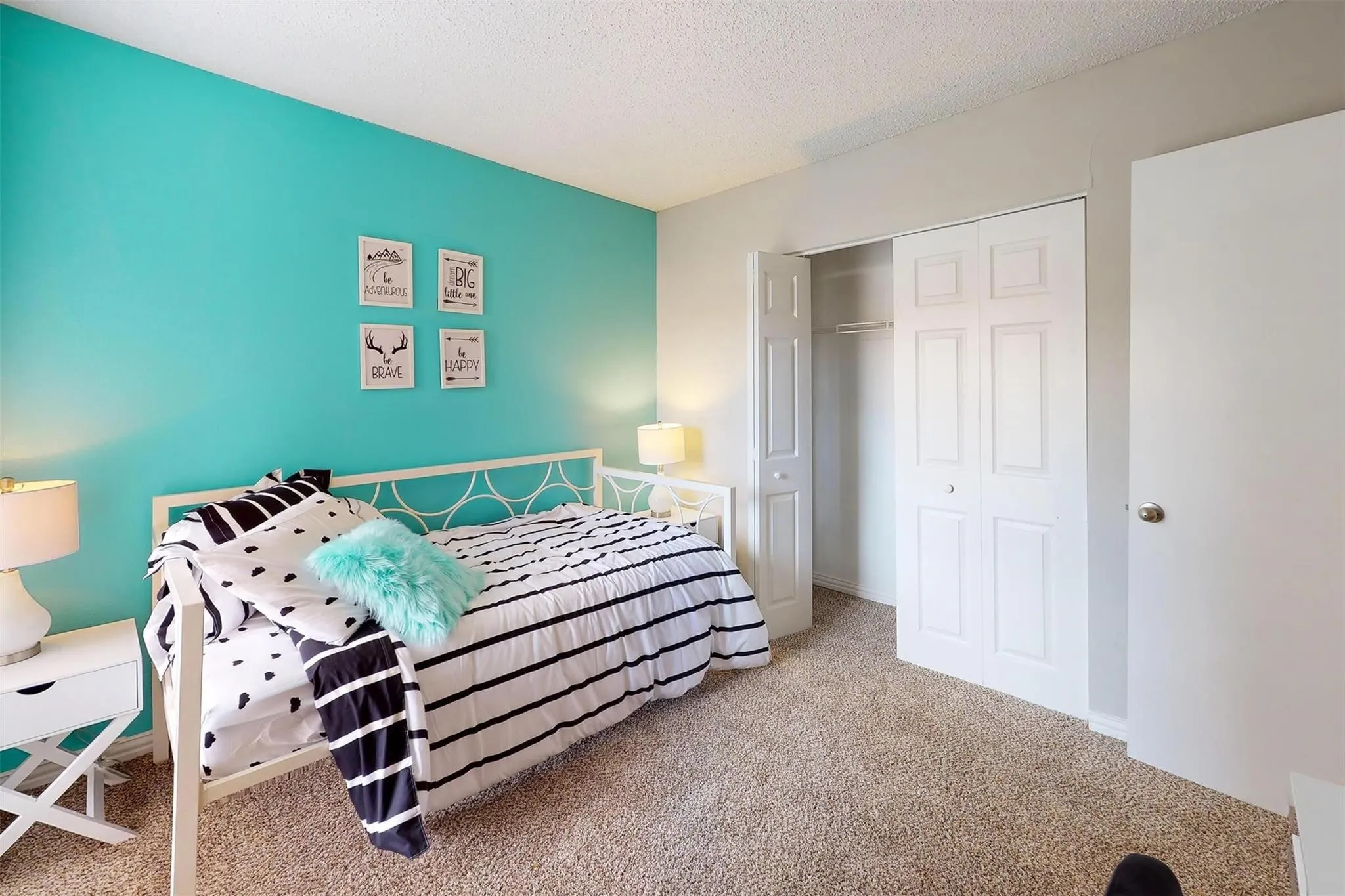 Carpeted flooring with a white bi-fold closet door and white interior door