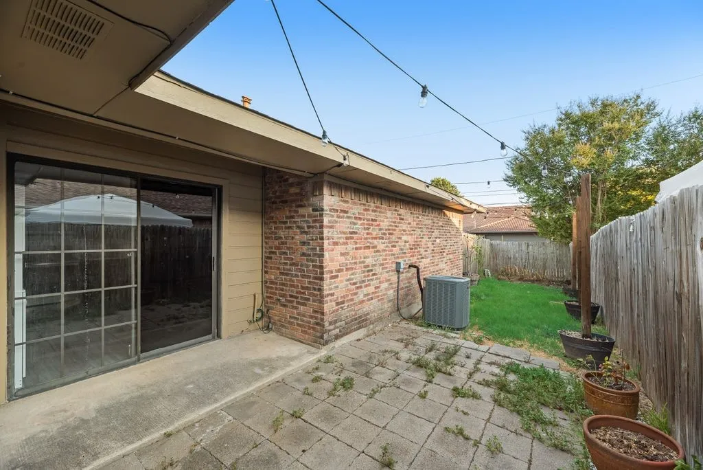 Private backyard featuring a concrete patio, sliding glass door access, and a wooden privacy fence