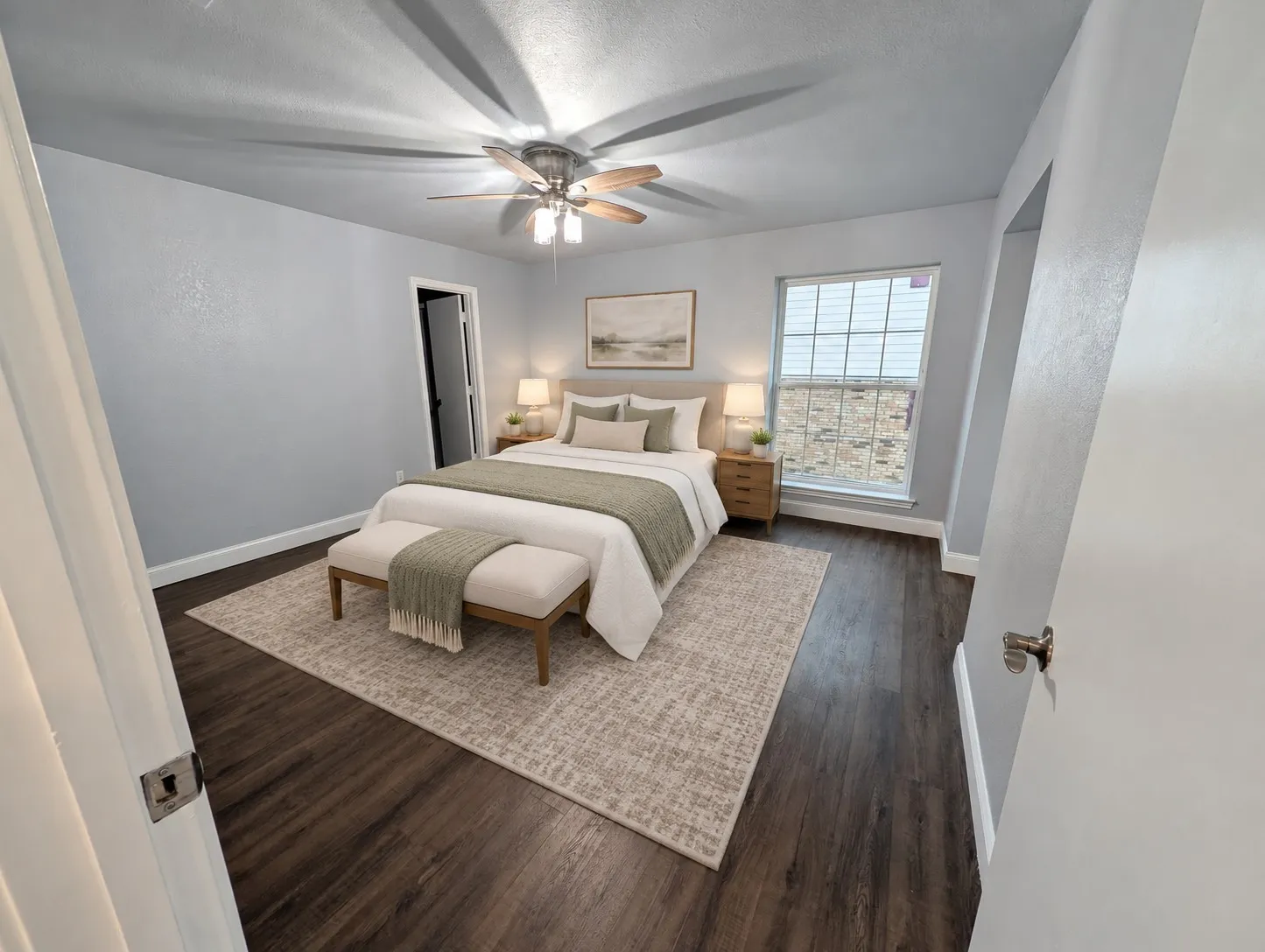 Wood-finish flooring with light-colored walls and a ceiling fan