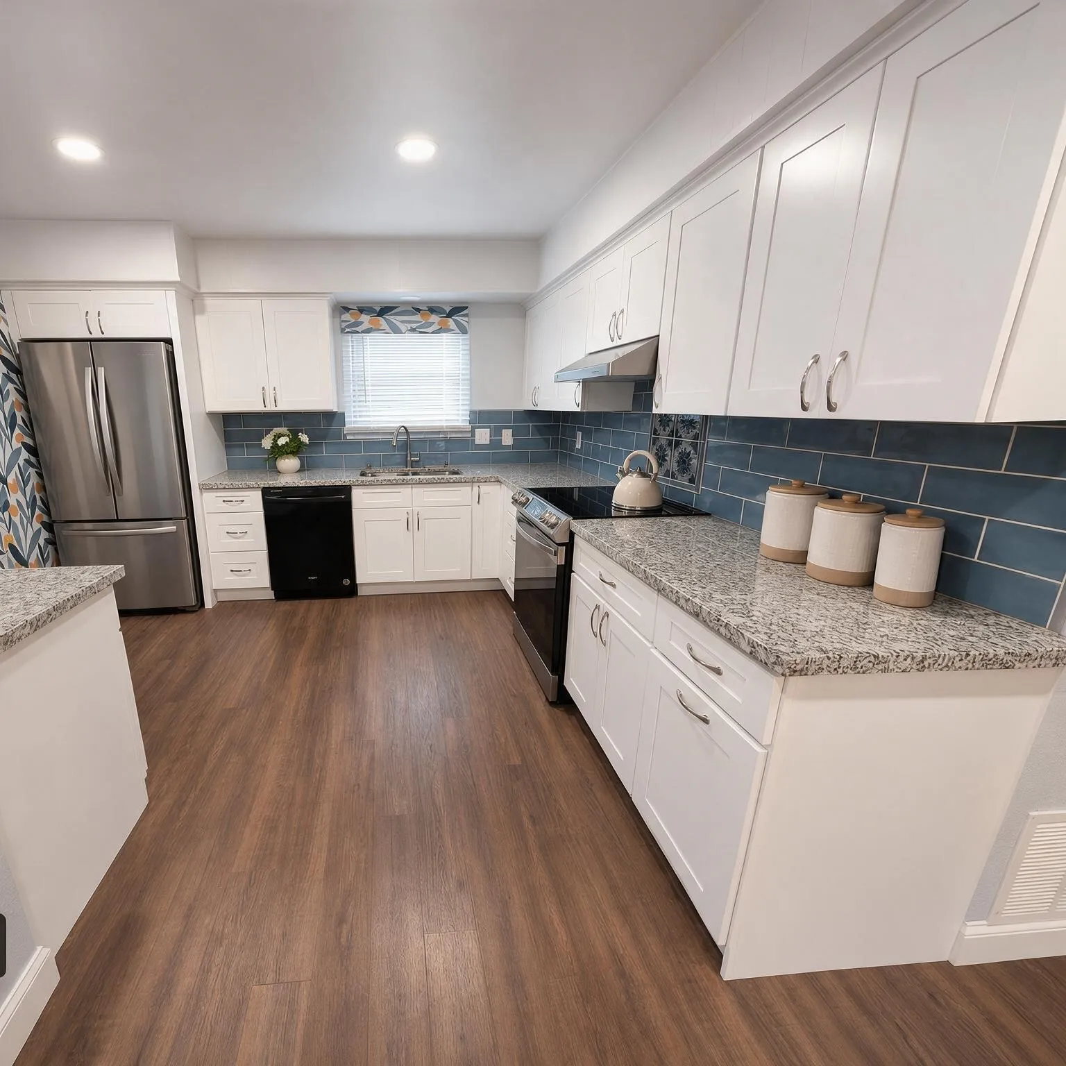 White cabinetry, wood-finish flooring, undermount sink, stainless steel appliances, and stone-look countertops