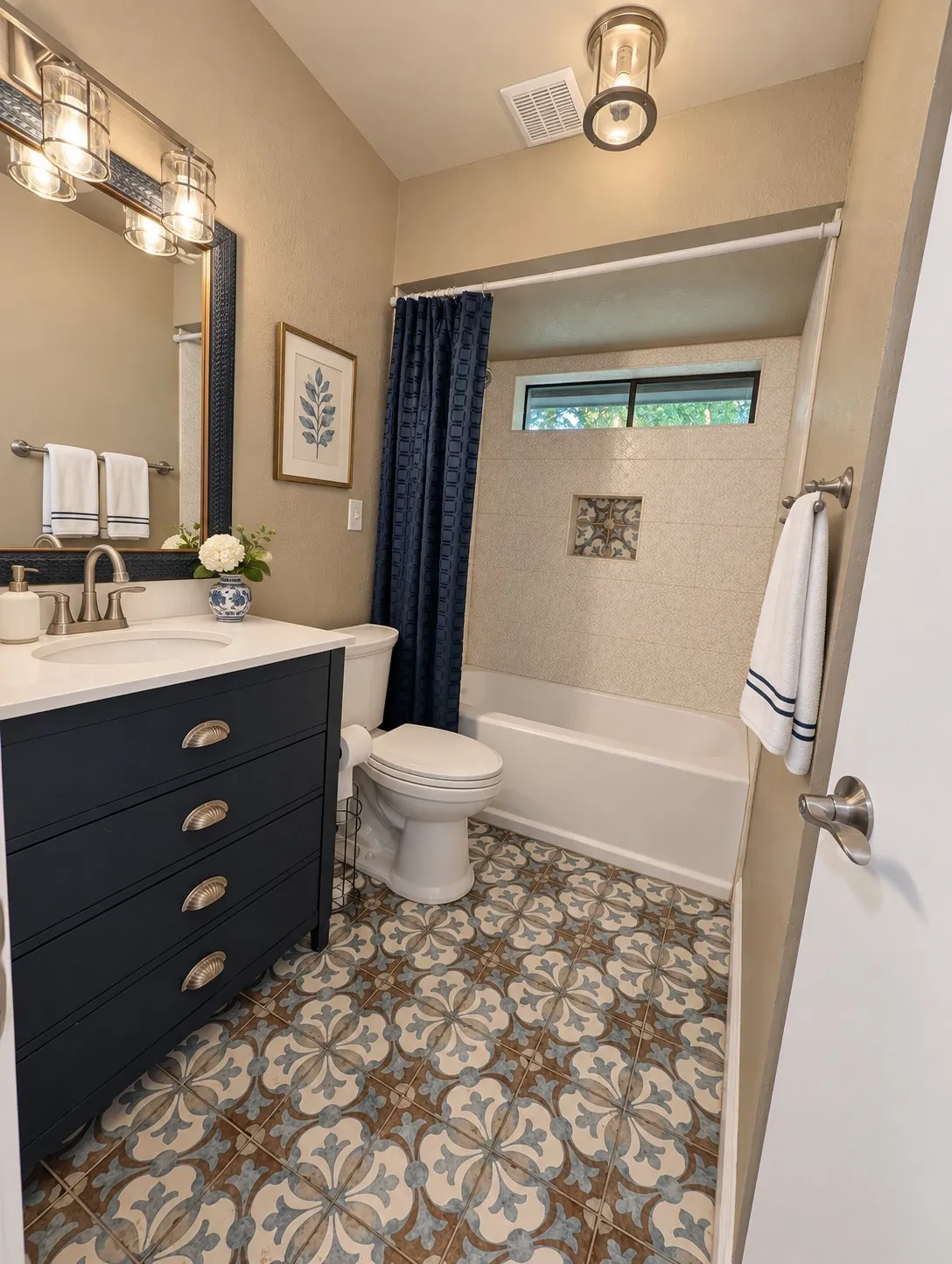 Patterned tile flooring, single vanity with integrated sink, contemporary vanity lighting, tiled shower surround, and a fixed window