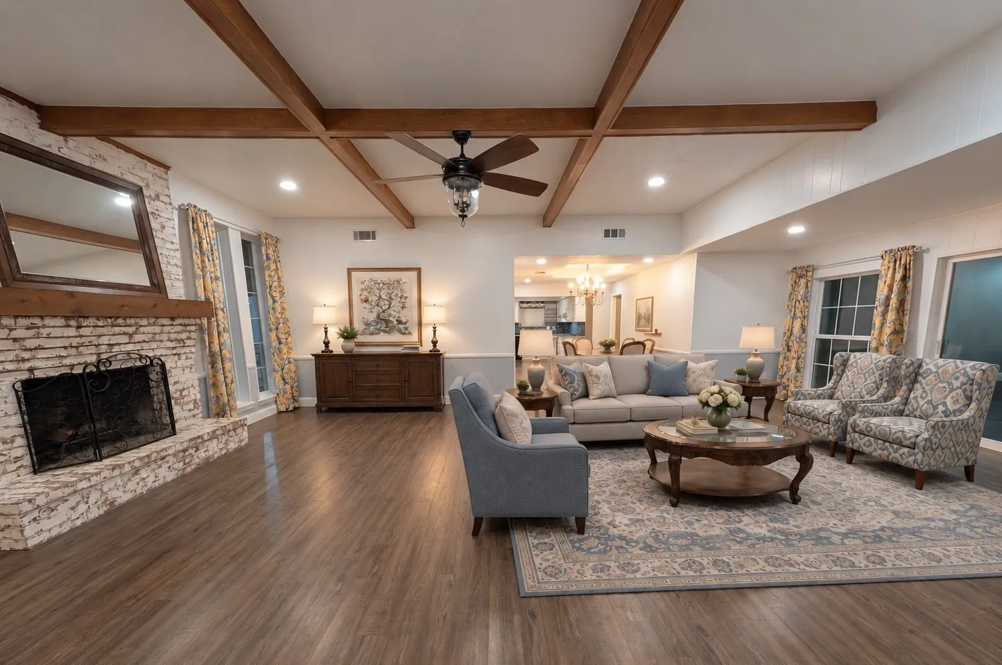 Whitewashed brick fireplace, exposed wood beams, wood-finish flooring, recessed lighting, and multiple windows