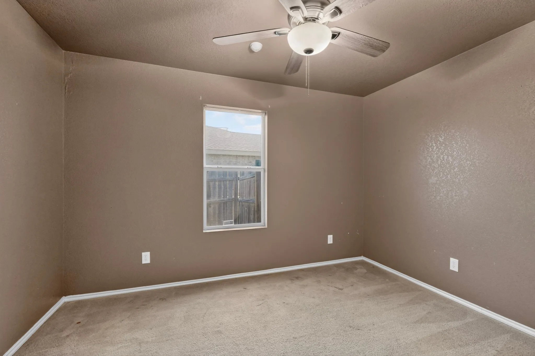 Room featuring a ceiling fan with integrated lighting, a single window, and carpet flooring