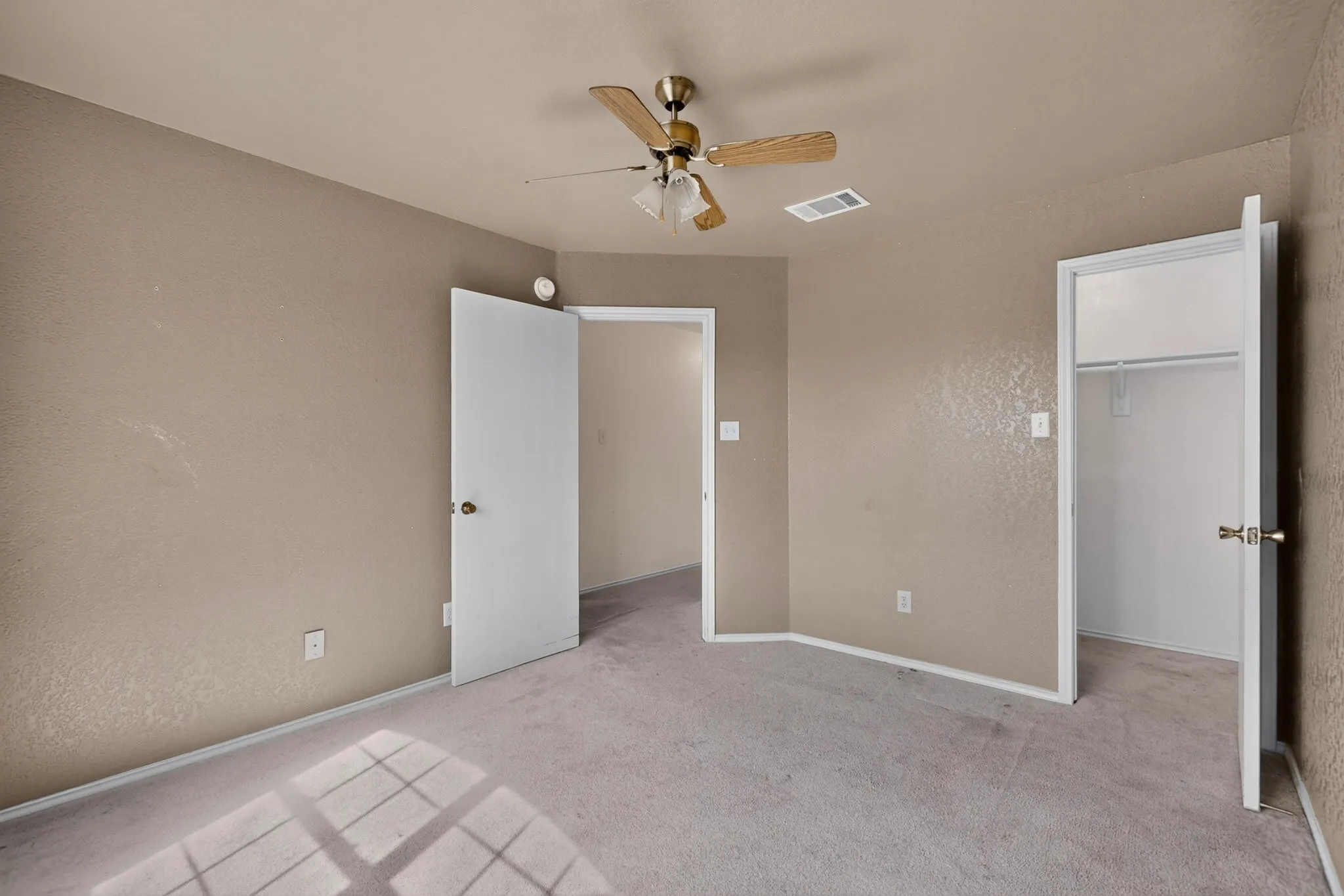 Neutral-toned walls complement plush carpeting
