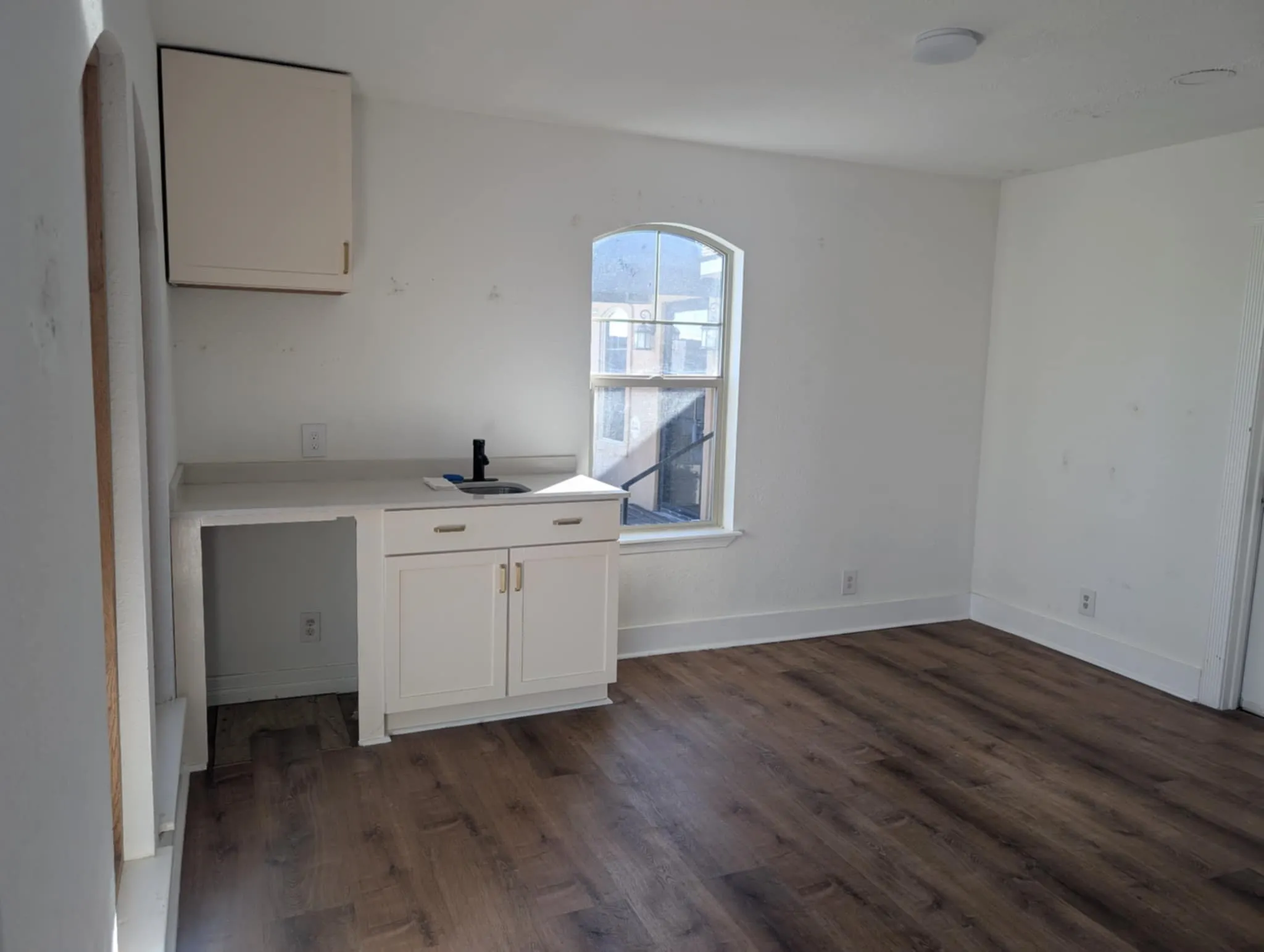 View of reception area with room for a mini fridge, sink, cabinet.