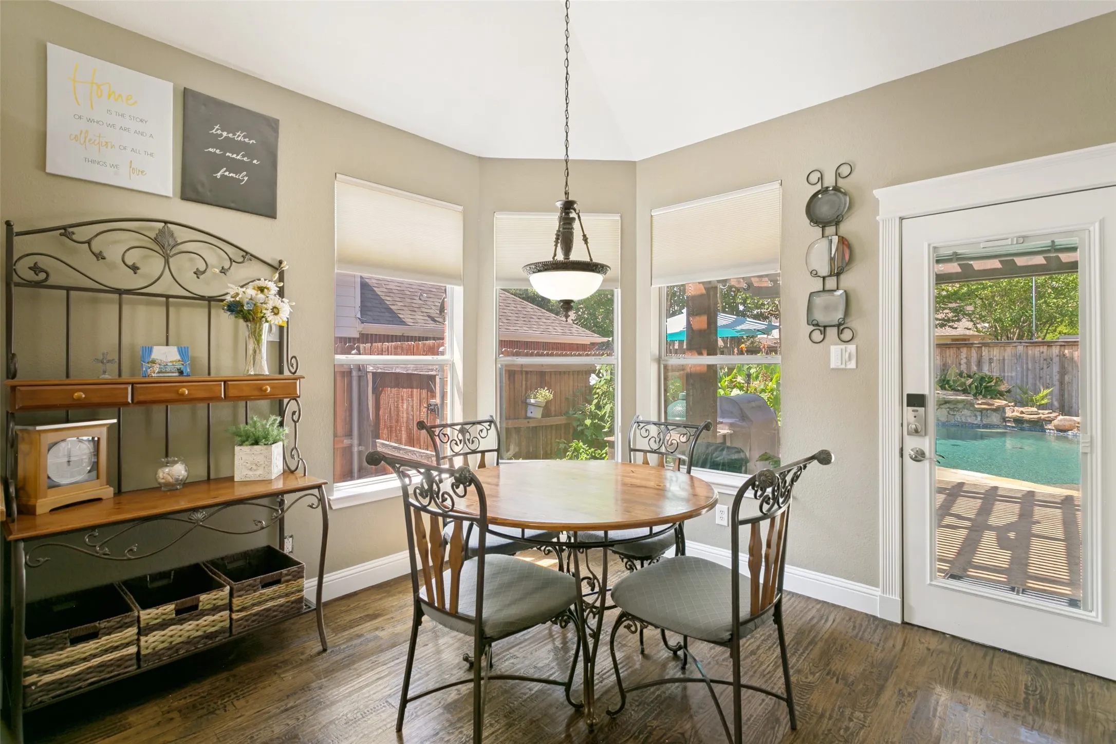 Kitchen eating area with multiple windows with roller shades, recessed lighting, and a glass-paneled door