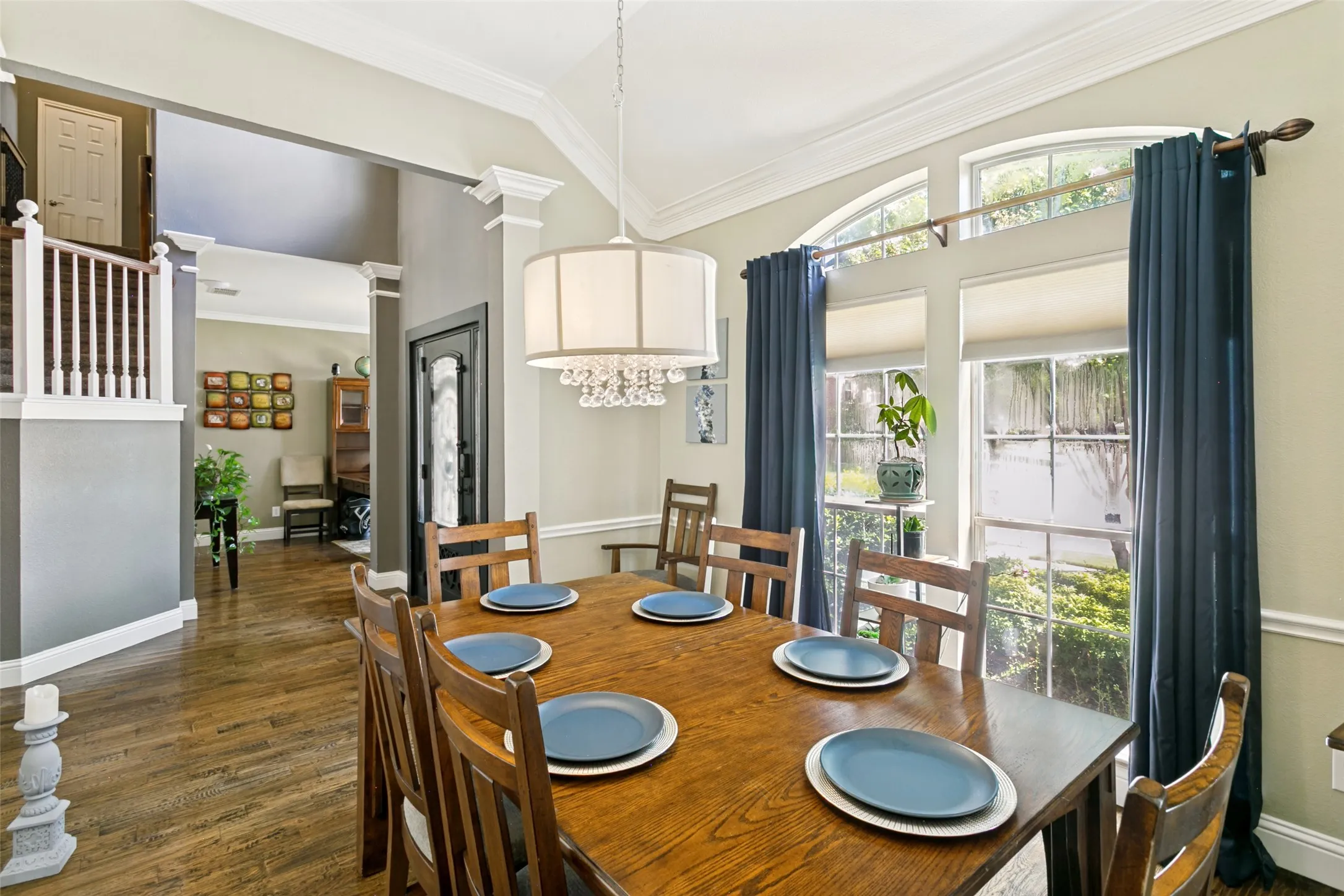 Dining area featuring arched transom windows, chandelier and wood-finish flooring