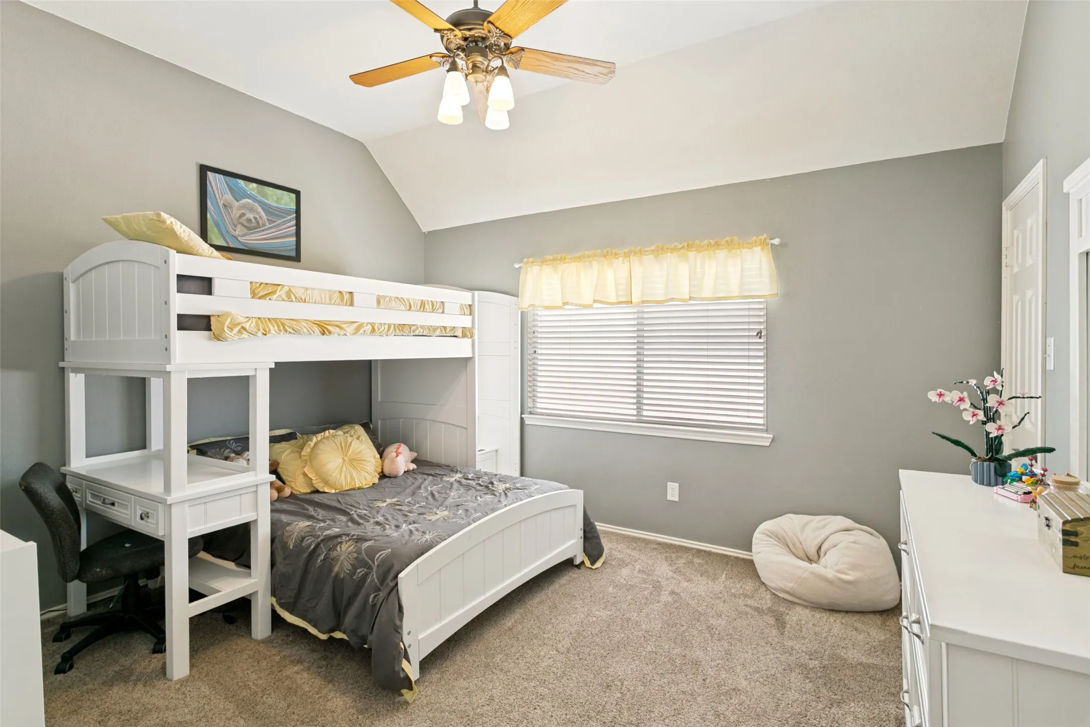 Vaulted ceiling with a ceiling fan light fixture, window with horizontal blinds, and neutral carpet flooring