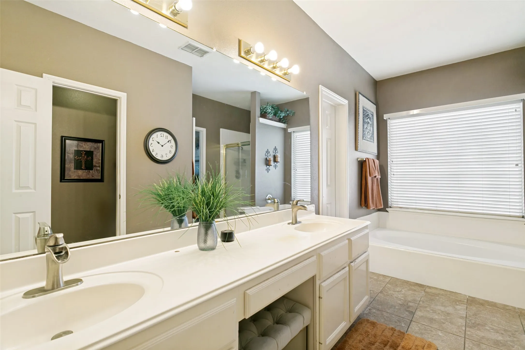 Primary bathroom with dual vanity and integrated sinks, brushed nickel faucets, and under-counter storage