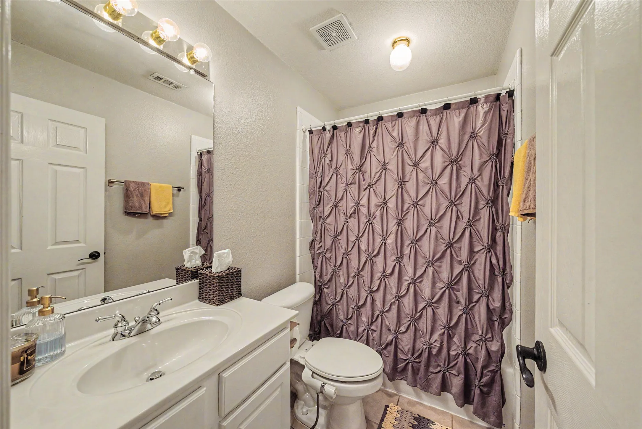 Single vanity with integrated sink, chrome faucet, and expansive wall-mounted mirror