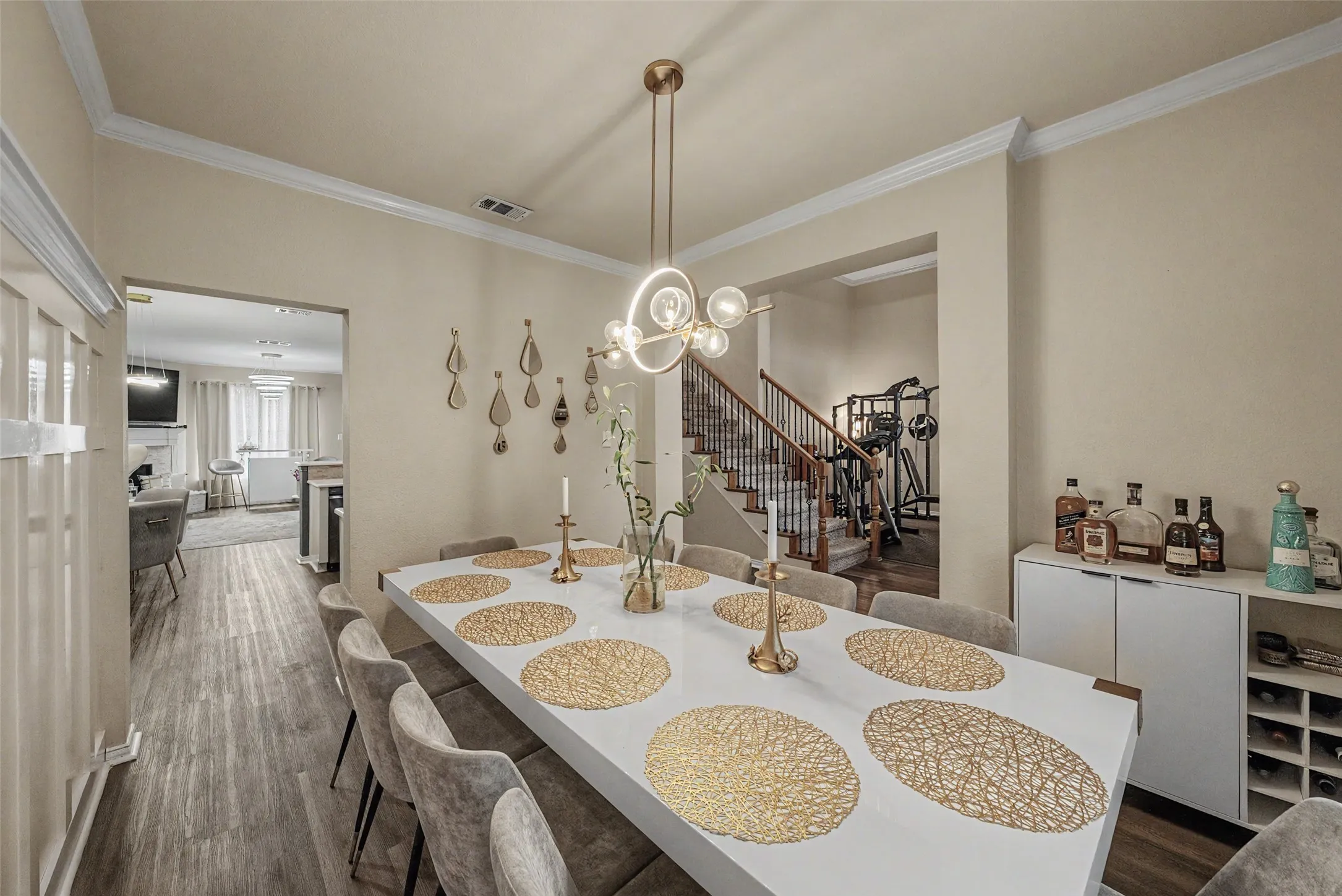 Formal dining area featuring wood-finish flooring, a contemporary chandelier, and crown molding
