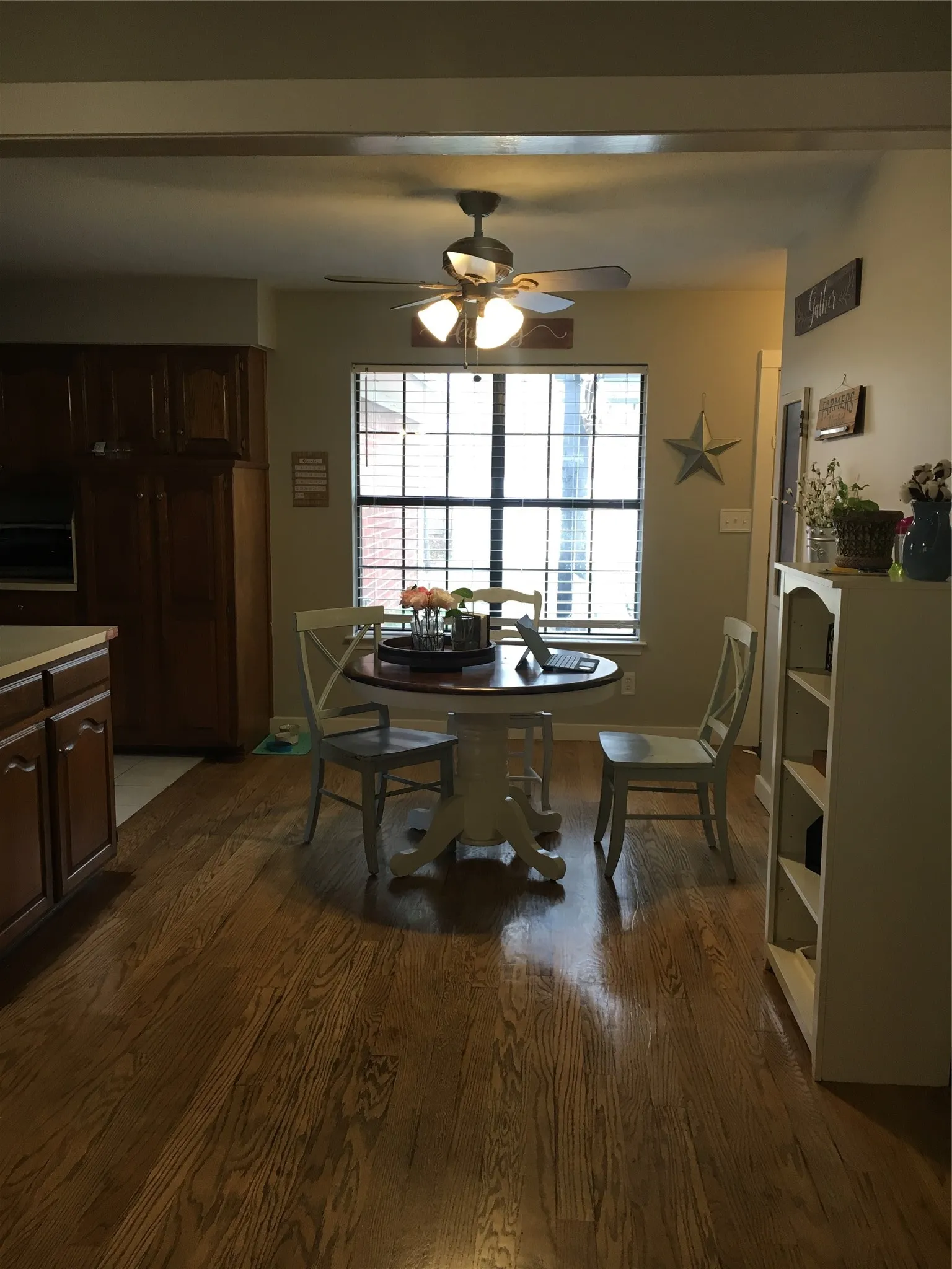 Wood-finish flooring throughout, with a recessed window featuring blinds