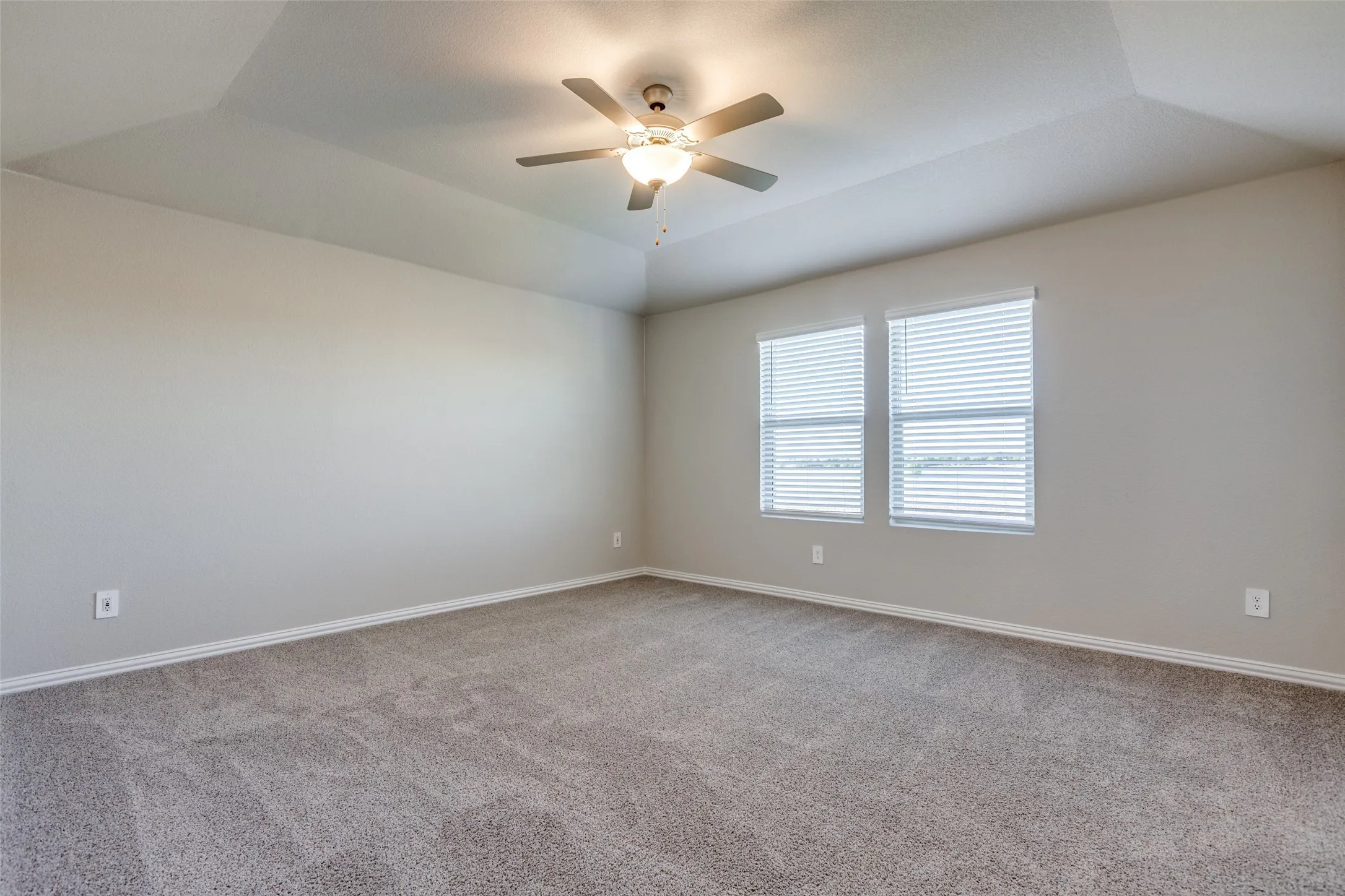 Empty room with ceiling fan, lofted ceiling, and carpet flooring
