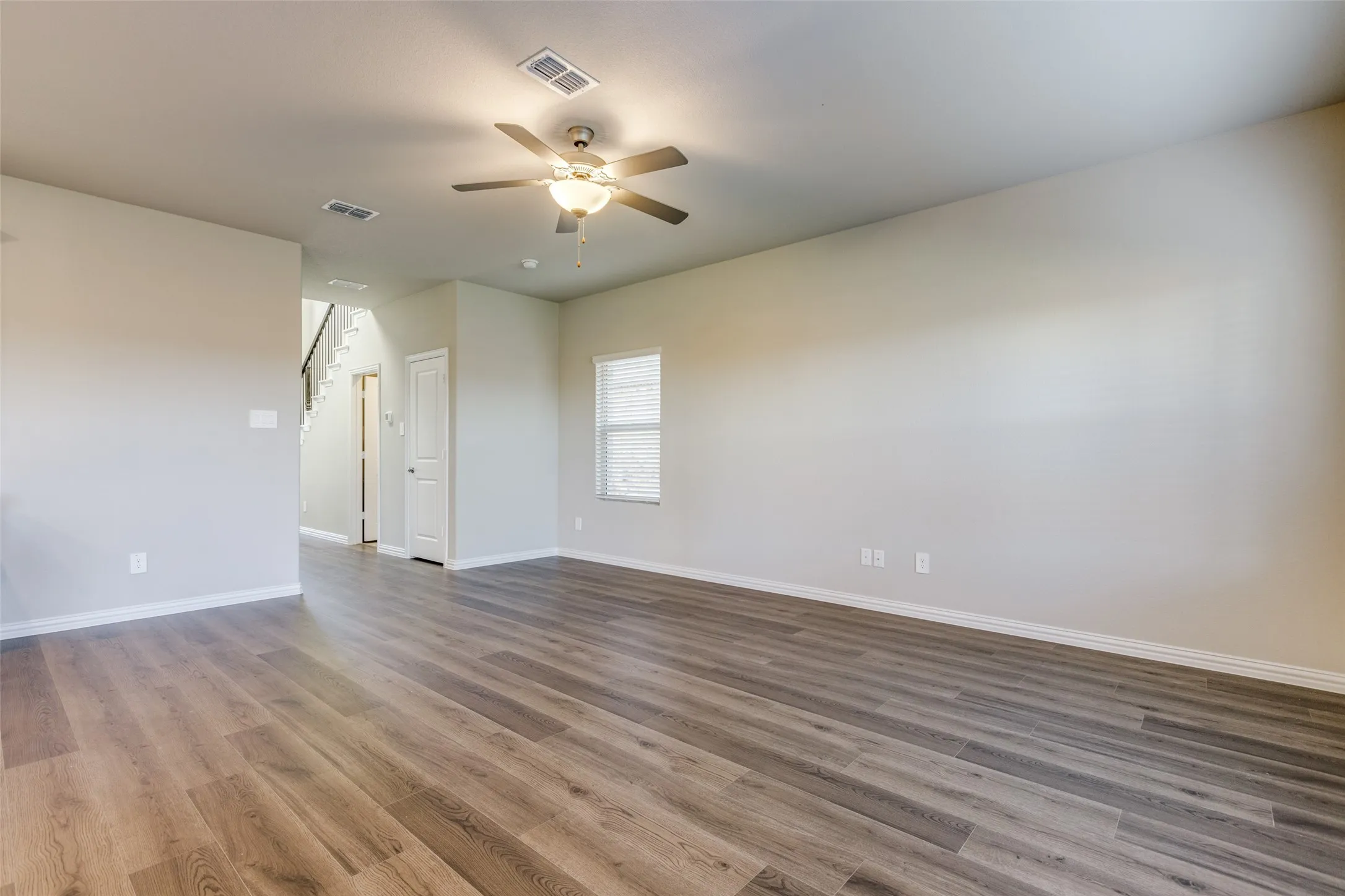 Spare room with hardwood / wood-style floors and ceiling fan
