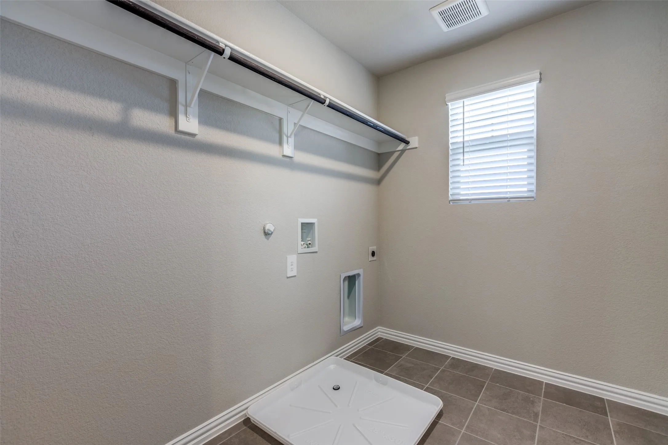 Laundry area featuring hookup for a washing machine, hookup for a gas dryer, electric dryer hookup, and dark tile patterned floors