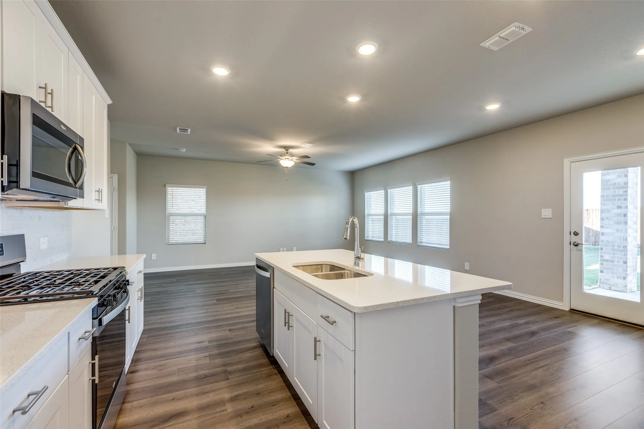 Kitchen with a center island with sink, white cabinetry, sink, and stainless steel appliances