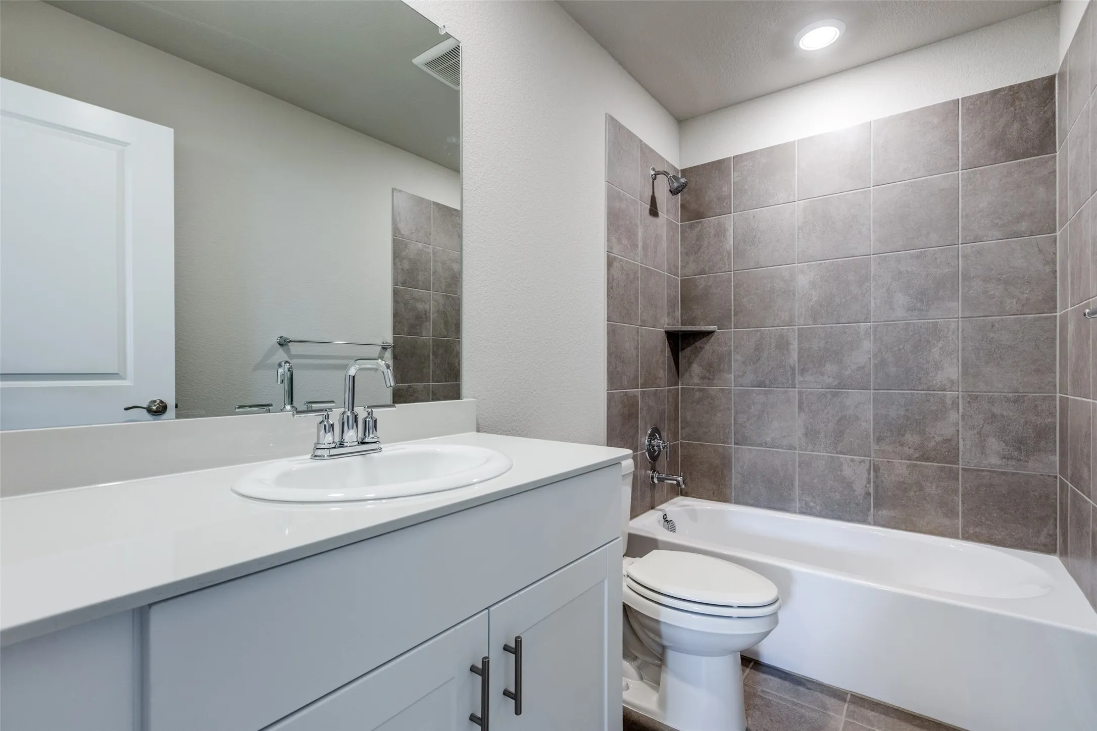 Full bathroom featuring vanity, toilet, and tiled shower / bath