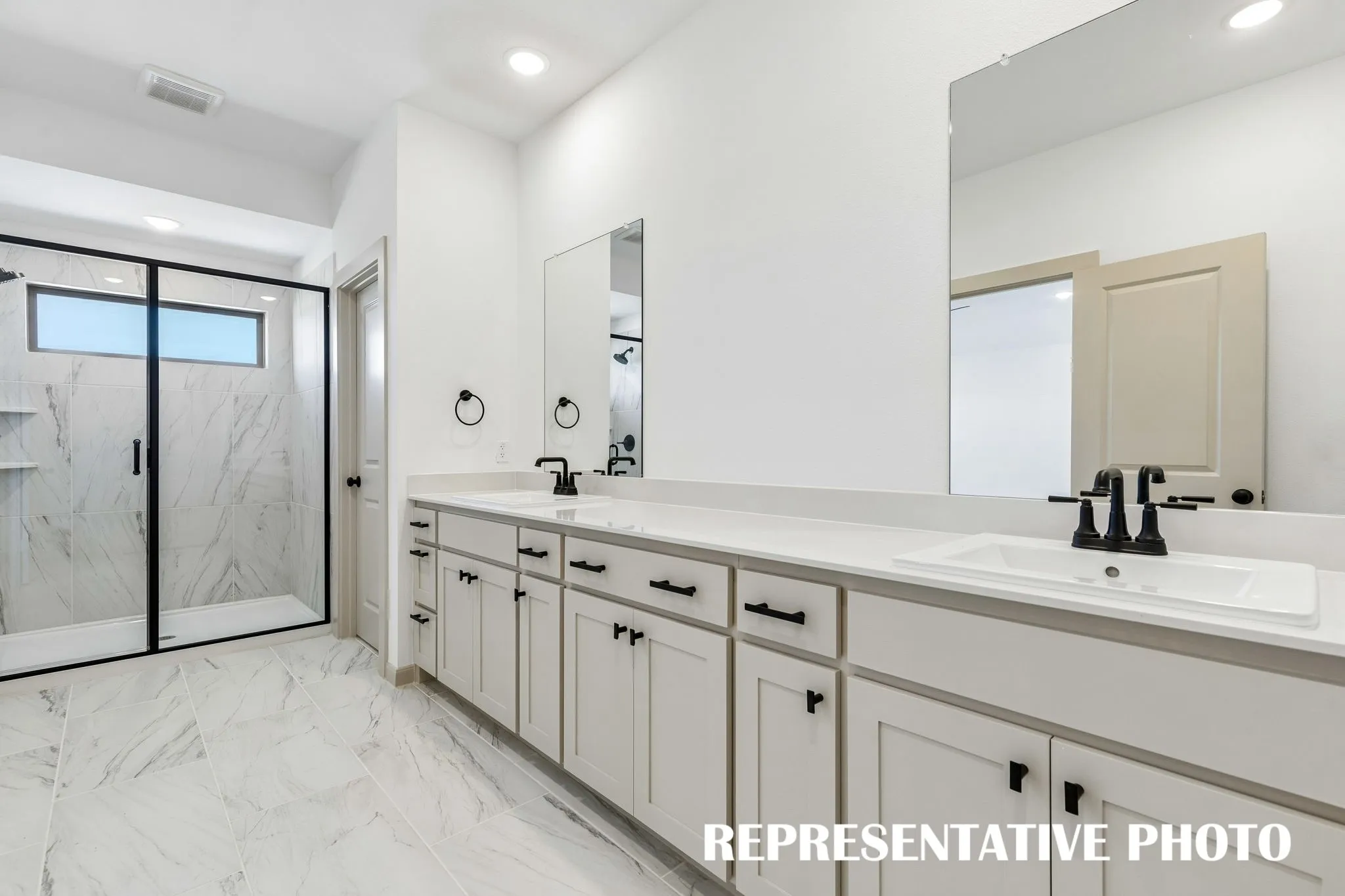 With ample room for two and a lovely walk in shower, this owner's bath is a dream come true!  REPRESENTATIVE PHOTO