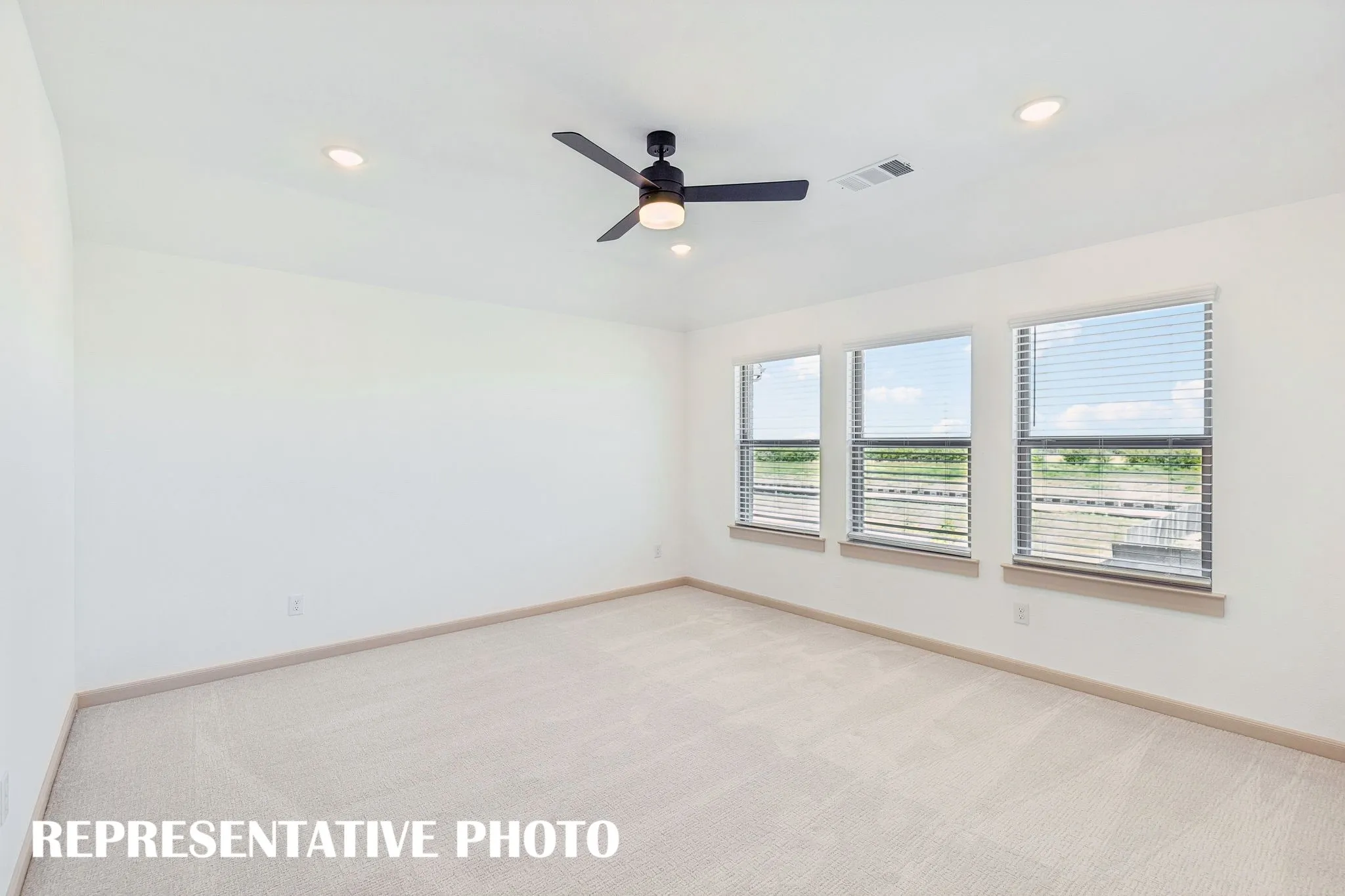 Featuring plush carpeting and a wall of windows, this wonderful owner's suite was designed for rest and relaxation.  REPRESENTATIVE PHOTO