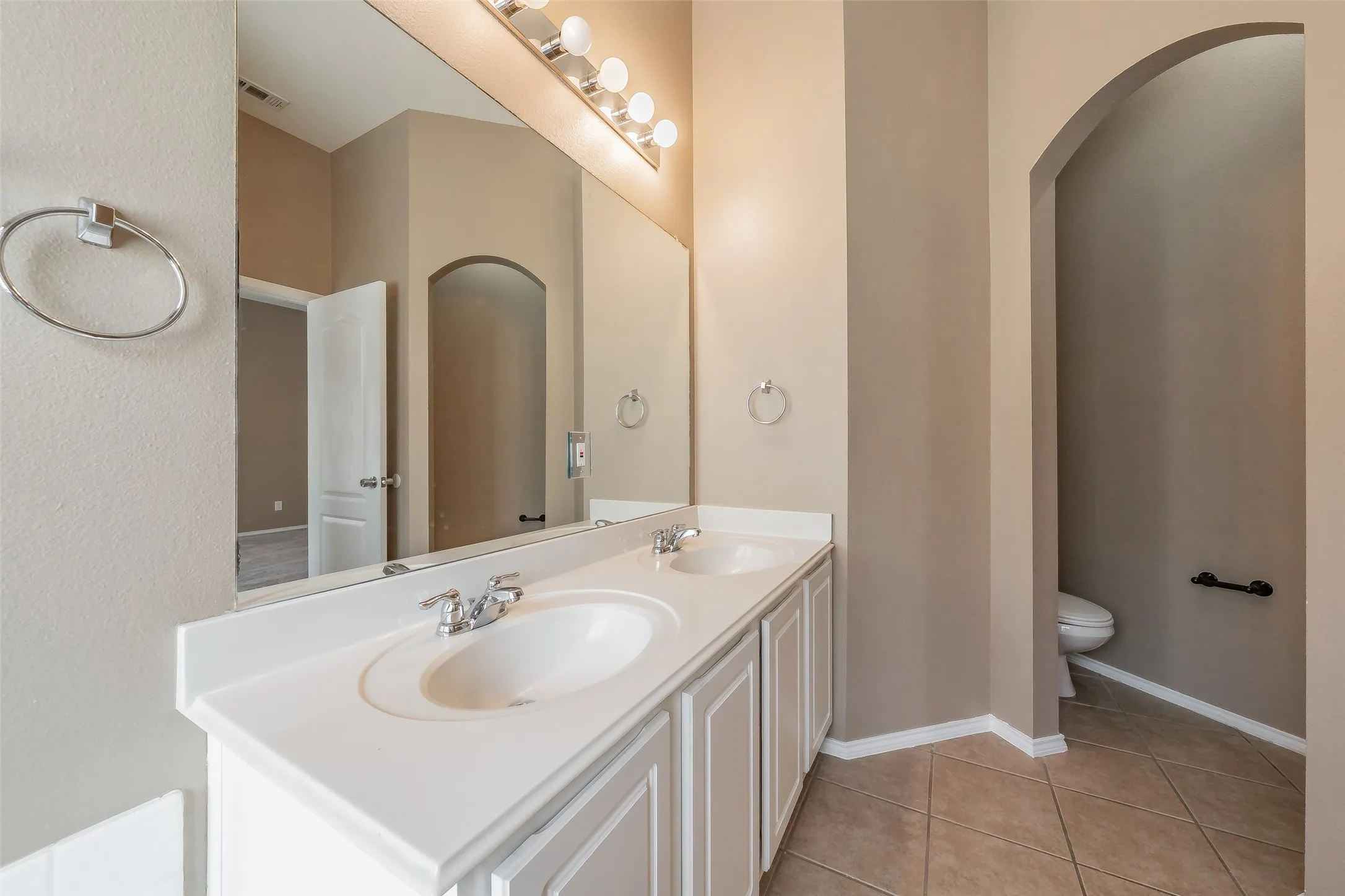Dual vanity with white cabinetry, integrated sinks, and chrome faucets